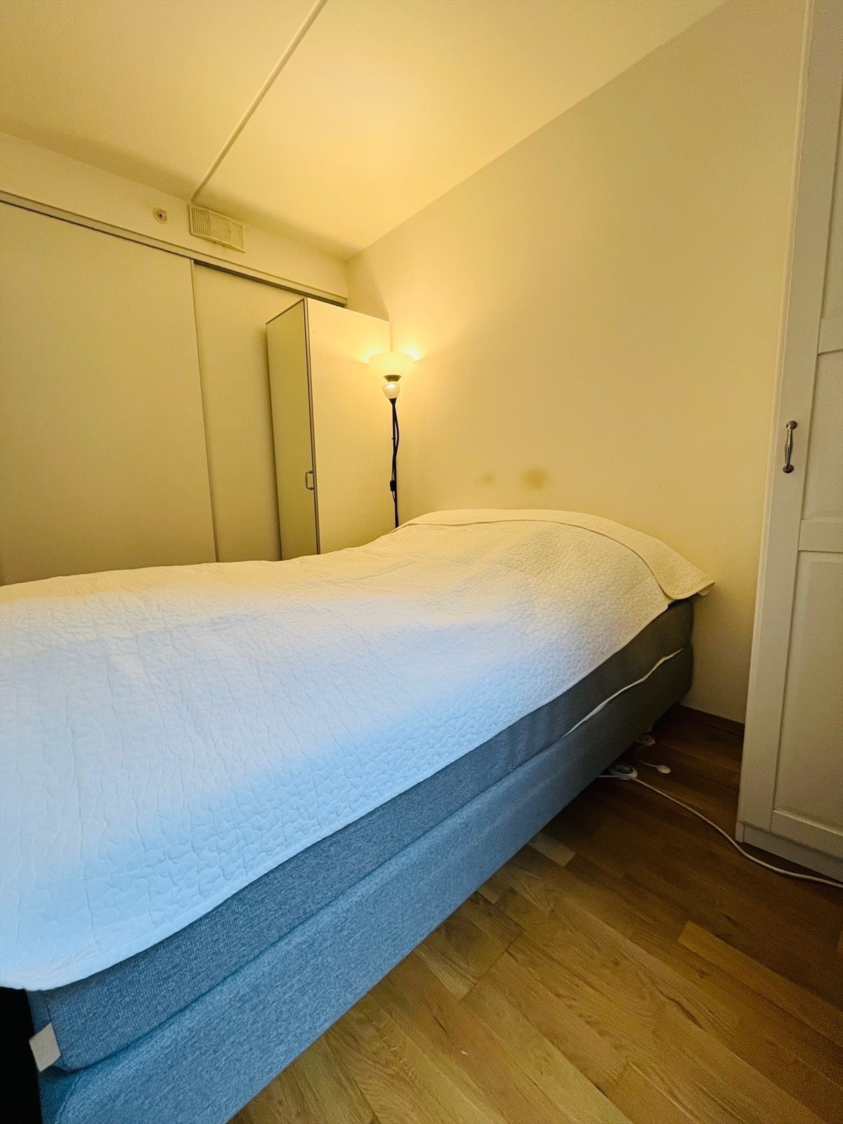 Del av soverom med praktisk skyvedørsgarderobe i bakgrunn. Galleribilde