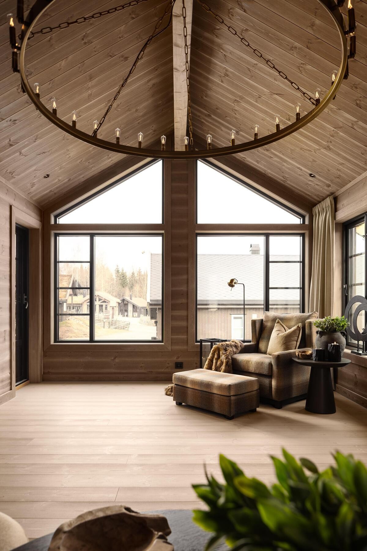 Panoramavinduer strekker seg helt opp til mønet i stuen. Foto fra visningshytte Rognli med oppstue på Hellerudsletta Galleribilde