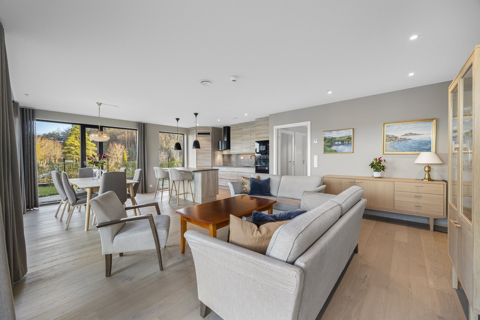 Stor og åpen stue/kjøkkenløsning med store vindusflater. Leiligheten ligger på en liten høyde og eier hagen utenfor slik at det er minimalt med innsyn. Galleribilde