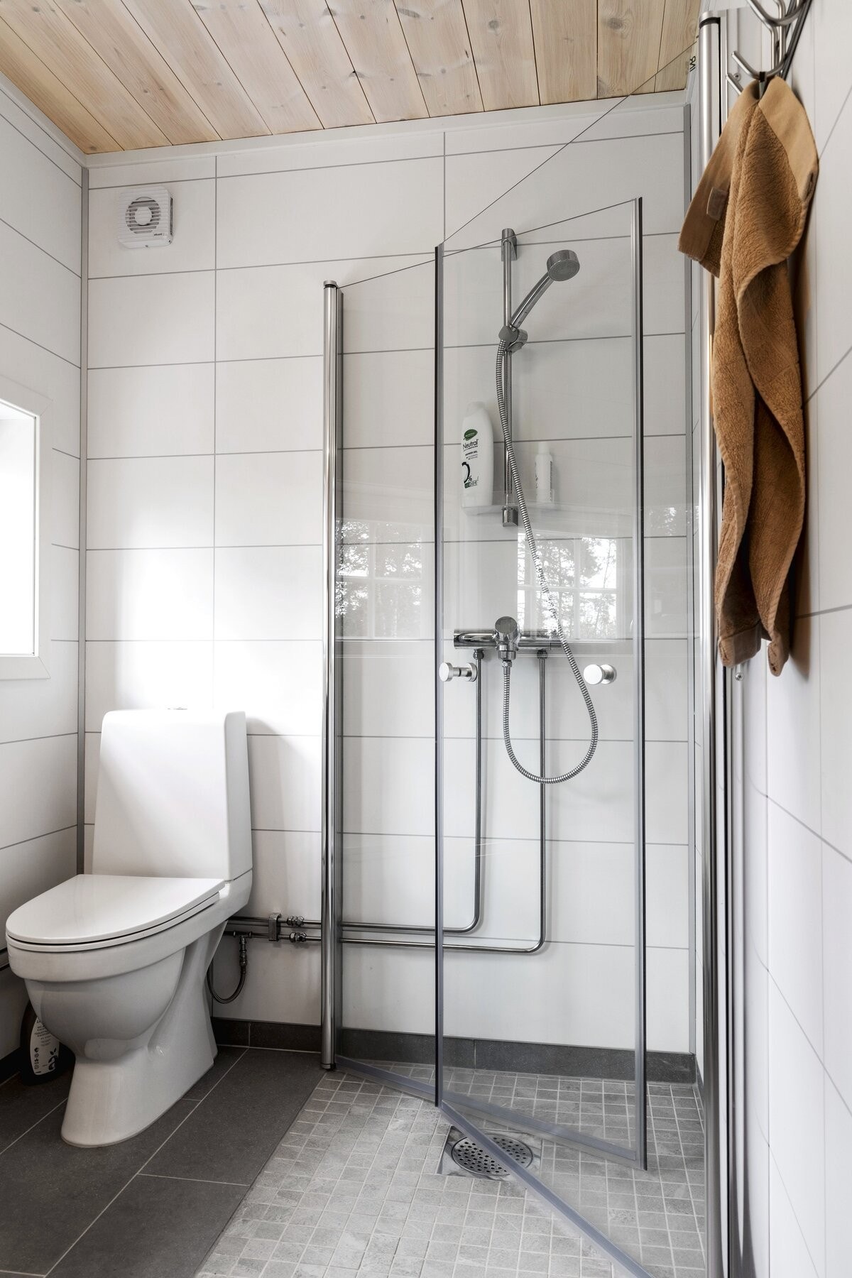 Badet er innredet med dusjhørne, toalett og servantskap med overskap. Galleribilde