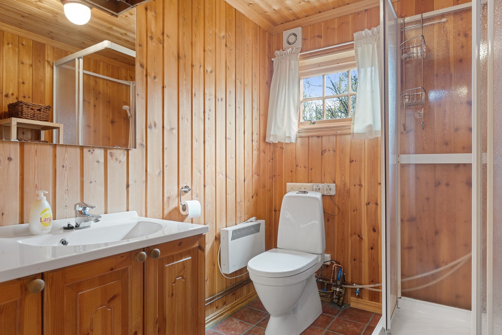 Badet har servantinnredning, toalett og dusjkabinett. Galleribilde