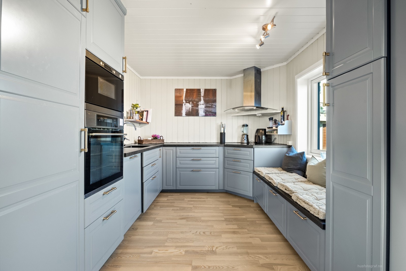 Pent utført kjøkken med innredning fra 2015 helt opp til taket og integrerte hvitevarer. Galleribilde