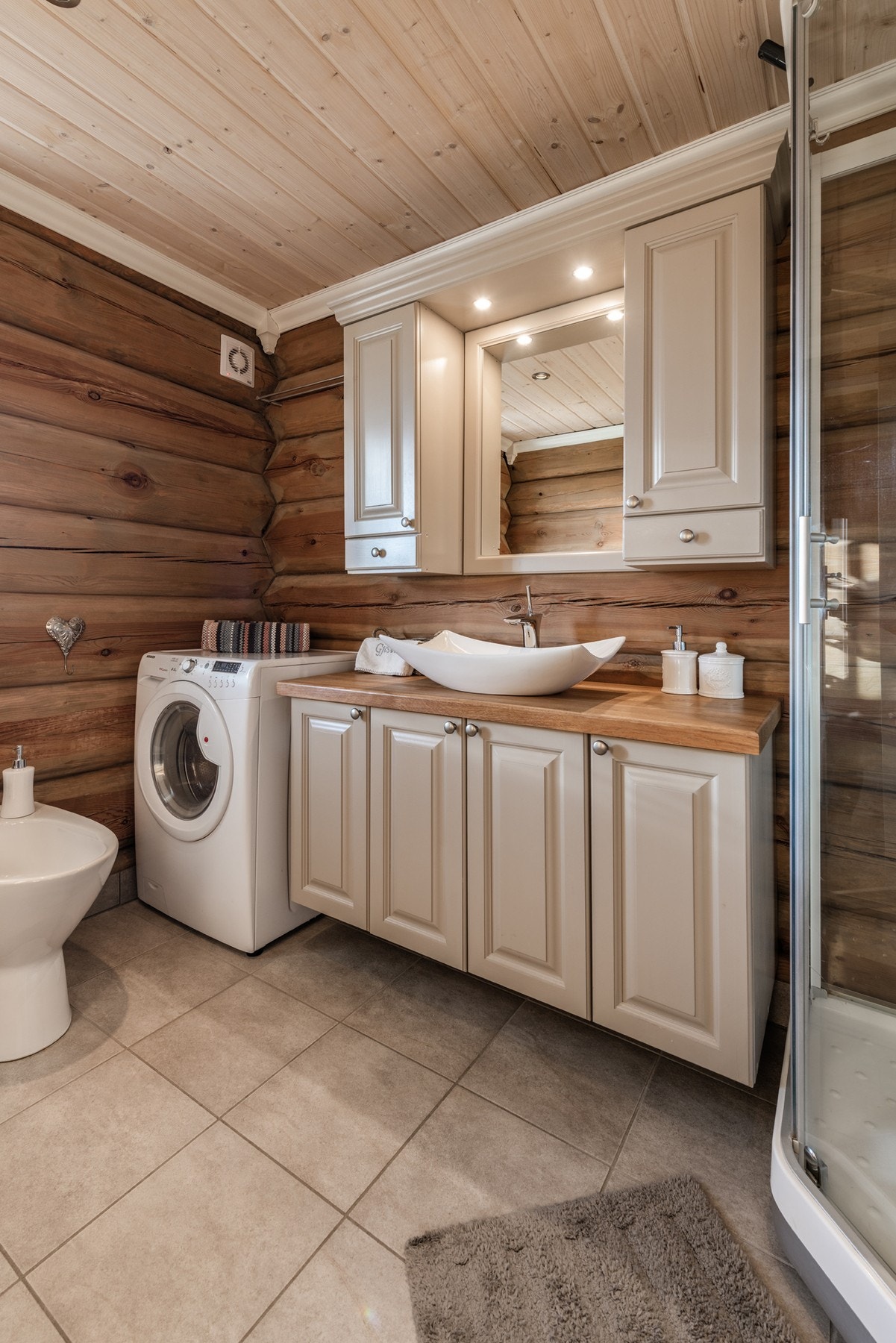 Badet er innredet med baderomsinnredning med servant, dusjkabinett, toalett og bidé. Galleribilde