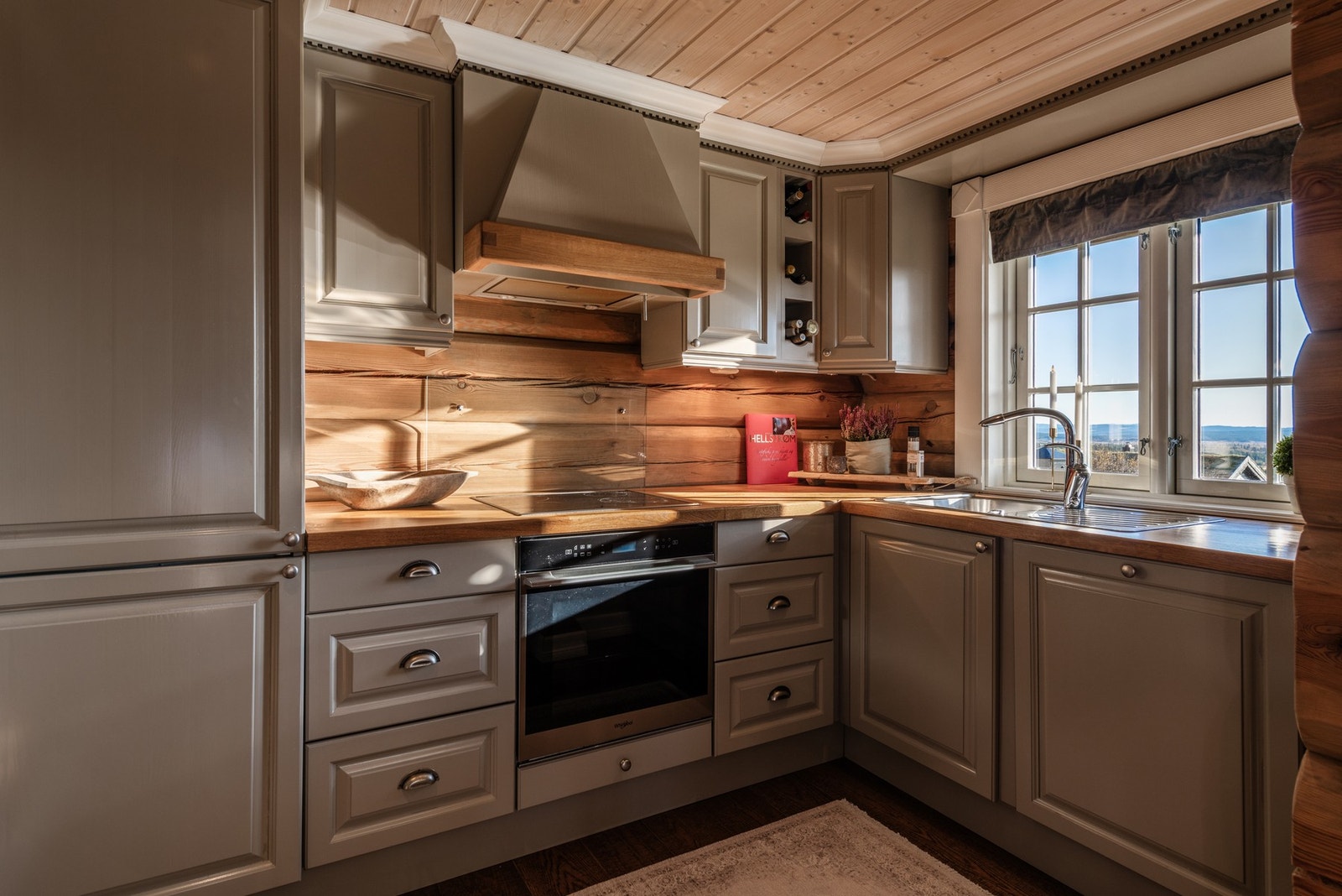 Kjøkkeninnredning med profilerte fronter, heltre benkeplate og nedfelt oppvaskkum. Galleribilde