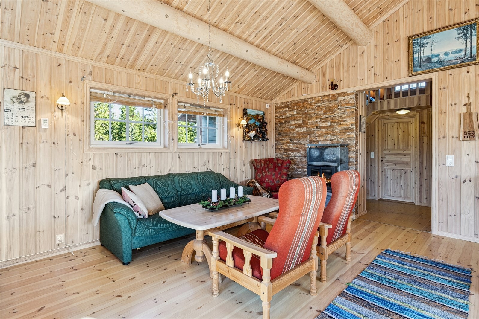 Tømmeråser i tak og panel på veggene gir den autentiske hyttefølelsen. Galleribilde