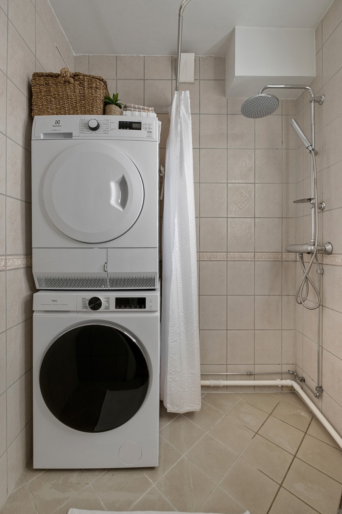Flislagt bad med plass til vaskemaskin og tørketrommel. Galleribilde