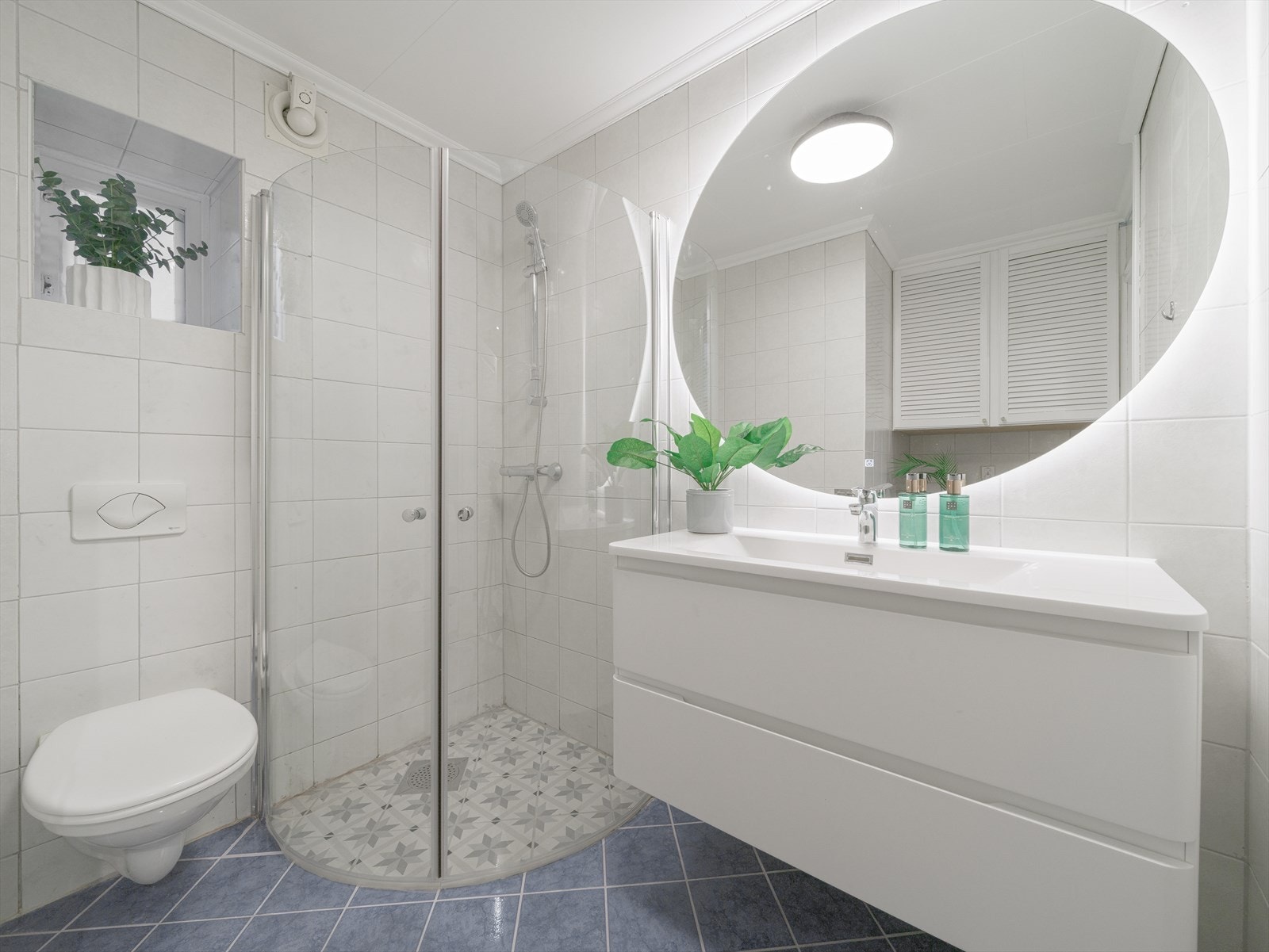 Pent, helfliset baderom med servantinnredning, speil, dusjhjørne og vegghengt toalett. Galleribilde