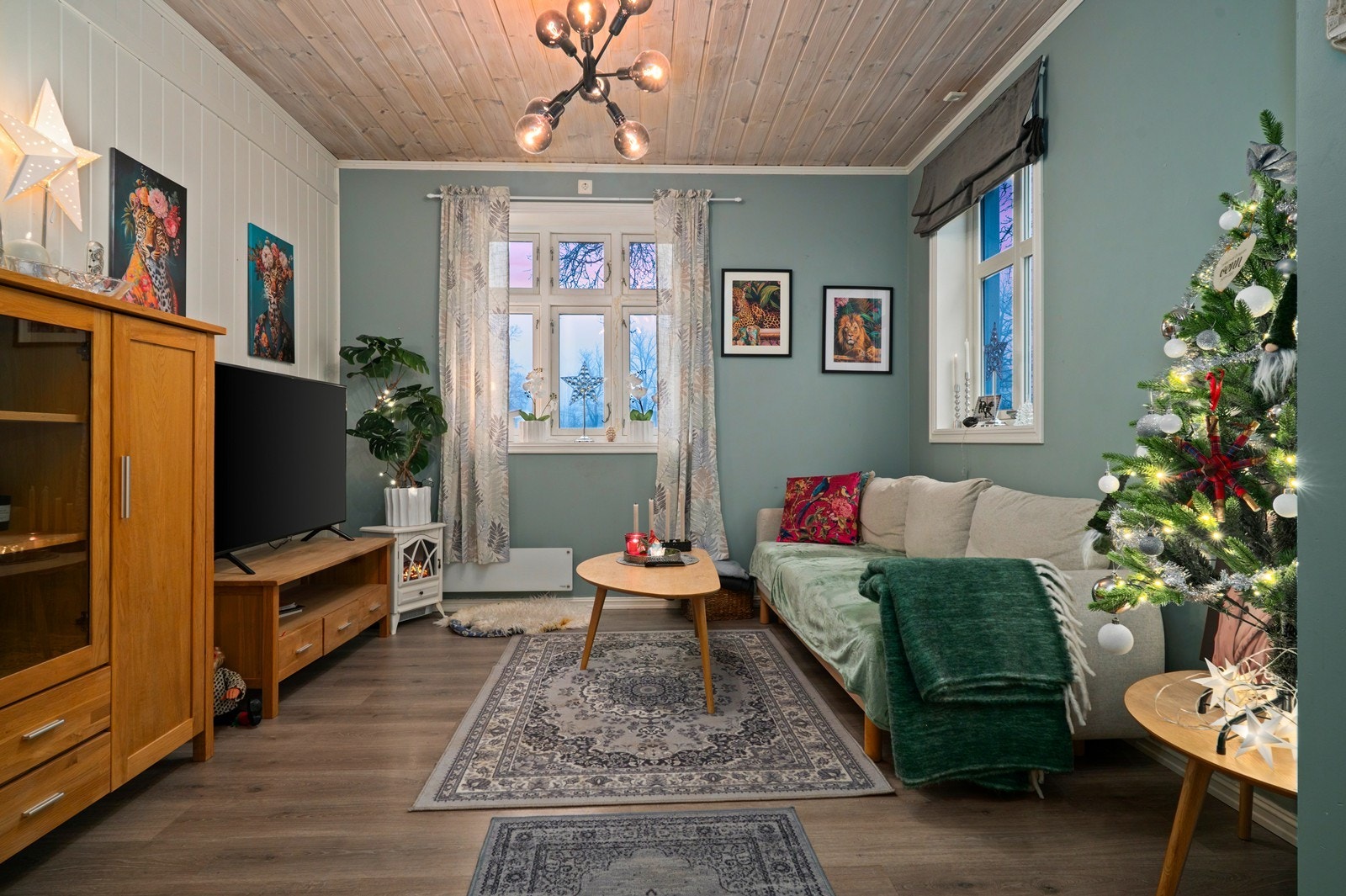 Laminatgulv og panelte vegger gir en hyggelig atmosfære i stuen. Vinduene slipper inn rikelig med naturlig lys. Galleribilde