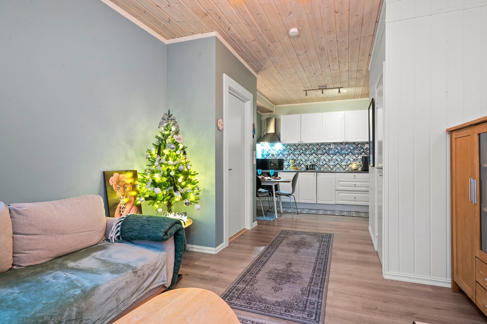 Lyst kjøkken med hvite fronter og flislagt bakvegg gir et stilrent uttrykk. Åpen løsning mot stuen skaper en romslig atmosfære. Galleribilde