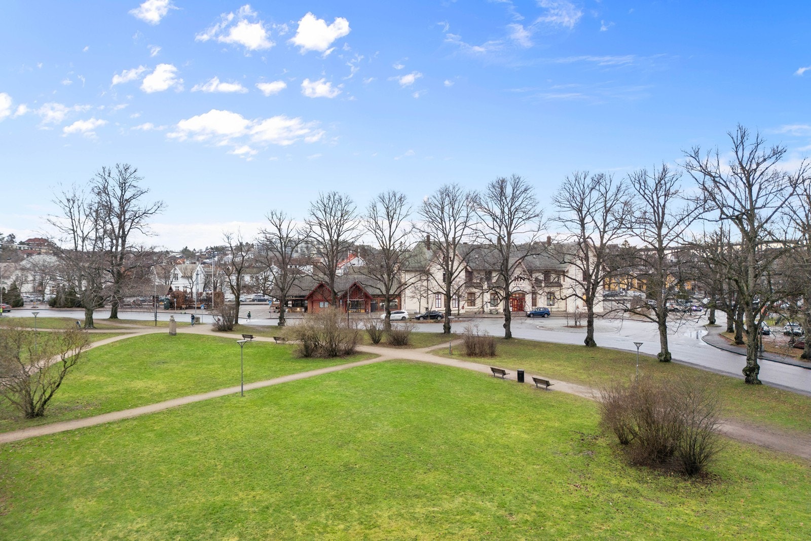 Utsikt over et åpent grøntområde med trær og gangstier gir en følelse av romslighet. Galleribilde