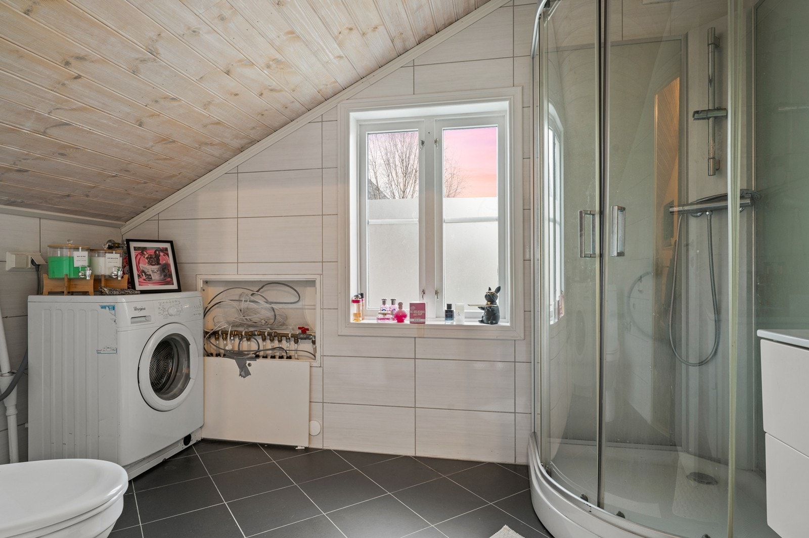 Flislagte vegger og gulv kombineres med en praktisk dusjkabinettløsning. Galleribilde