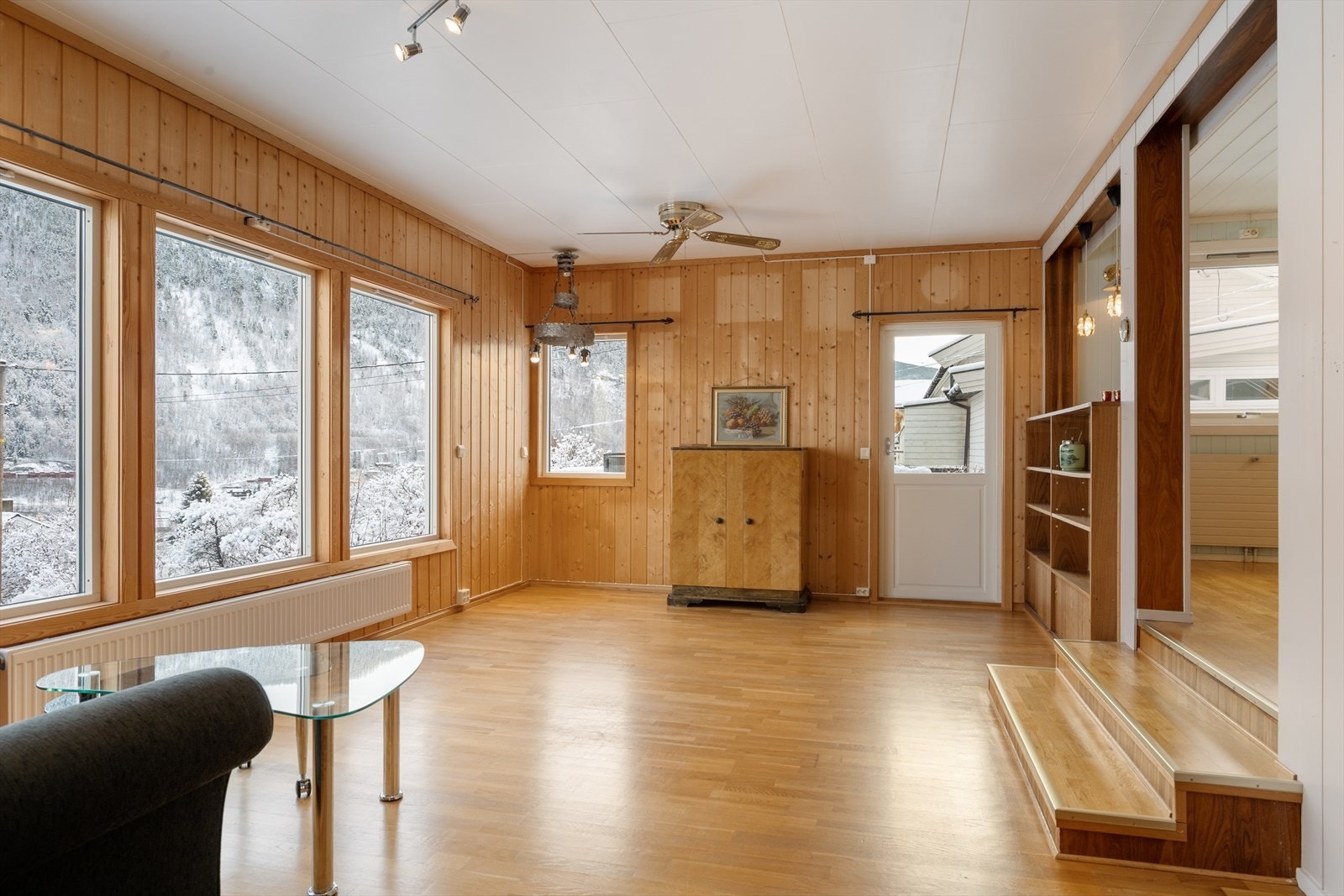 Lun stue med panelte vegger og parkettgulv. Galleribilde