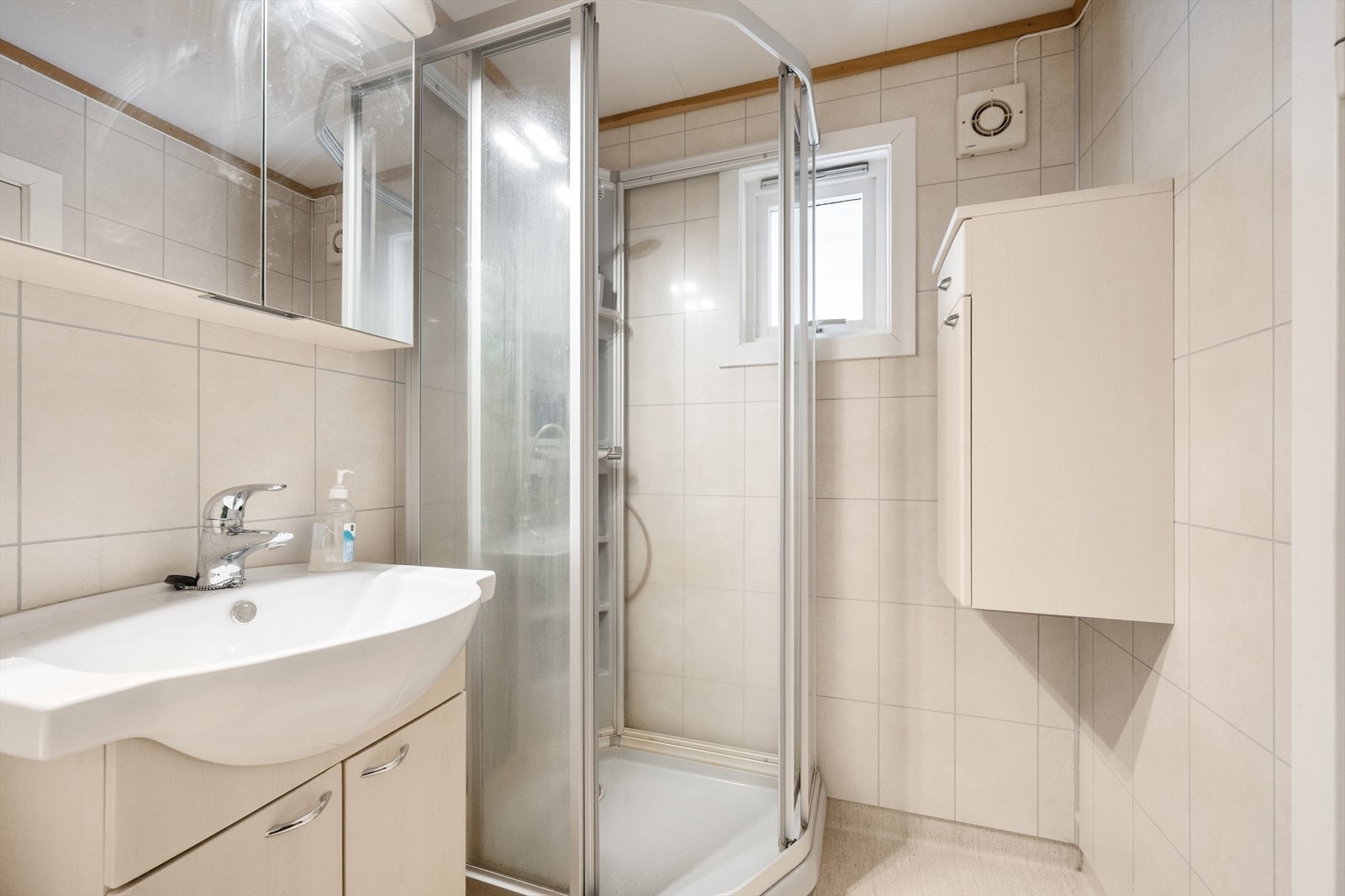 Lyst bad med baderomsplater på vegg og belegg på gulv. Galleribilde