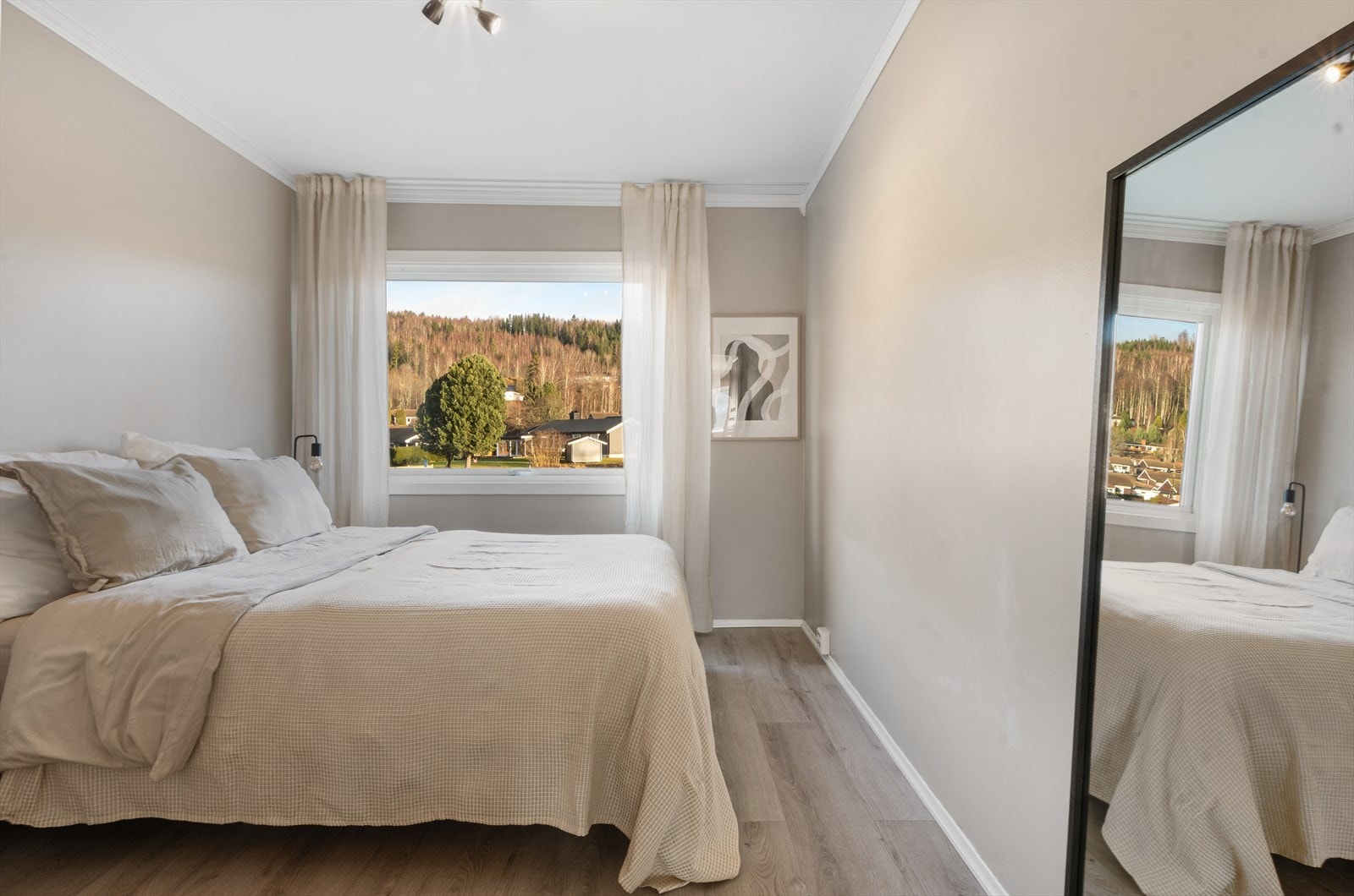 Gulvene er gjennomgående like i det meste av leiligheten og veggene på dette soverommet er slette og malt i samme delikate farge som i stuen. Galleribilde