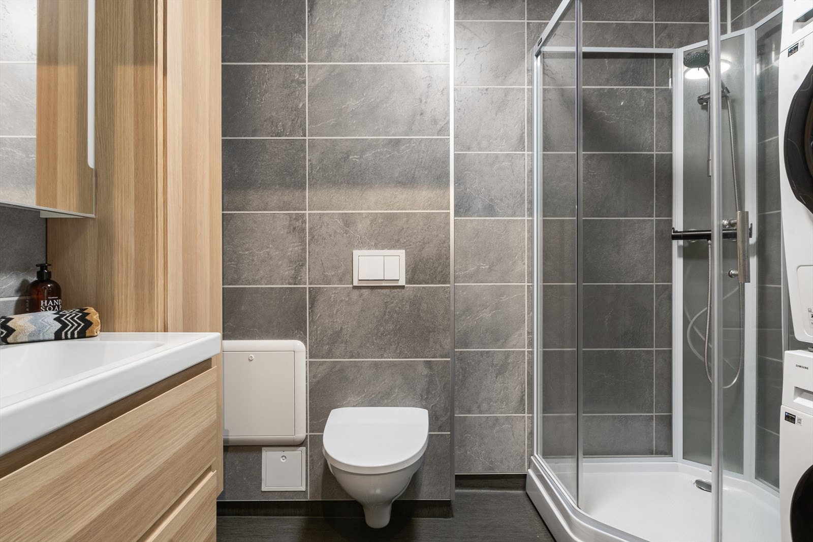 Tidløst fargevalg i grått på våtromsplatene og vinylbelegget. Galleribilde