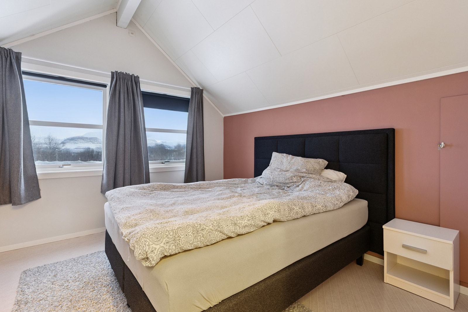 Hovedsoverommet har god takhøyde, to utsiktsvinduer og er malt i moderne farger. Galleribilde