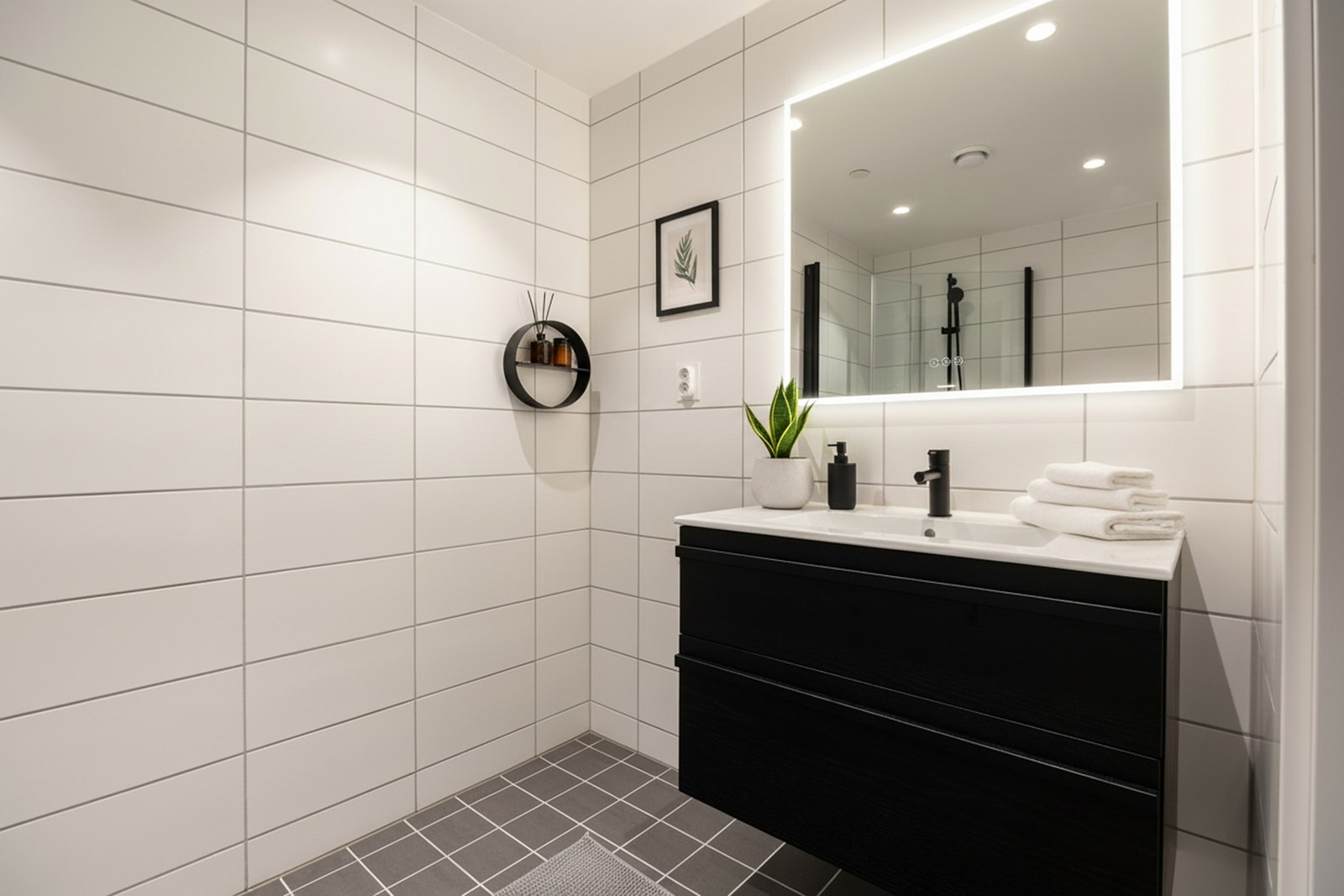 Tidløs innredning og stort speil med LED-lys. Galleribilde