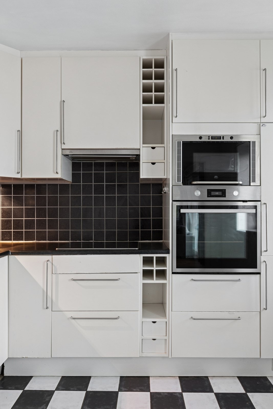 Kjøkkenet er innredet med slette fronter og benkeplate i laminat. Det er integrert platetopp, stekeovn, mikrobølgeovn og kombinert kjøl og fryseskap Galleribilde