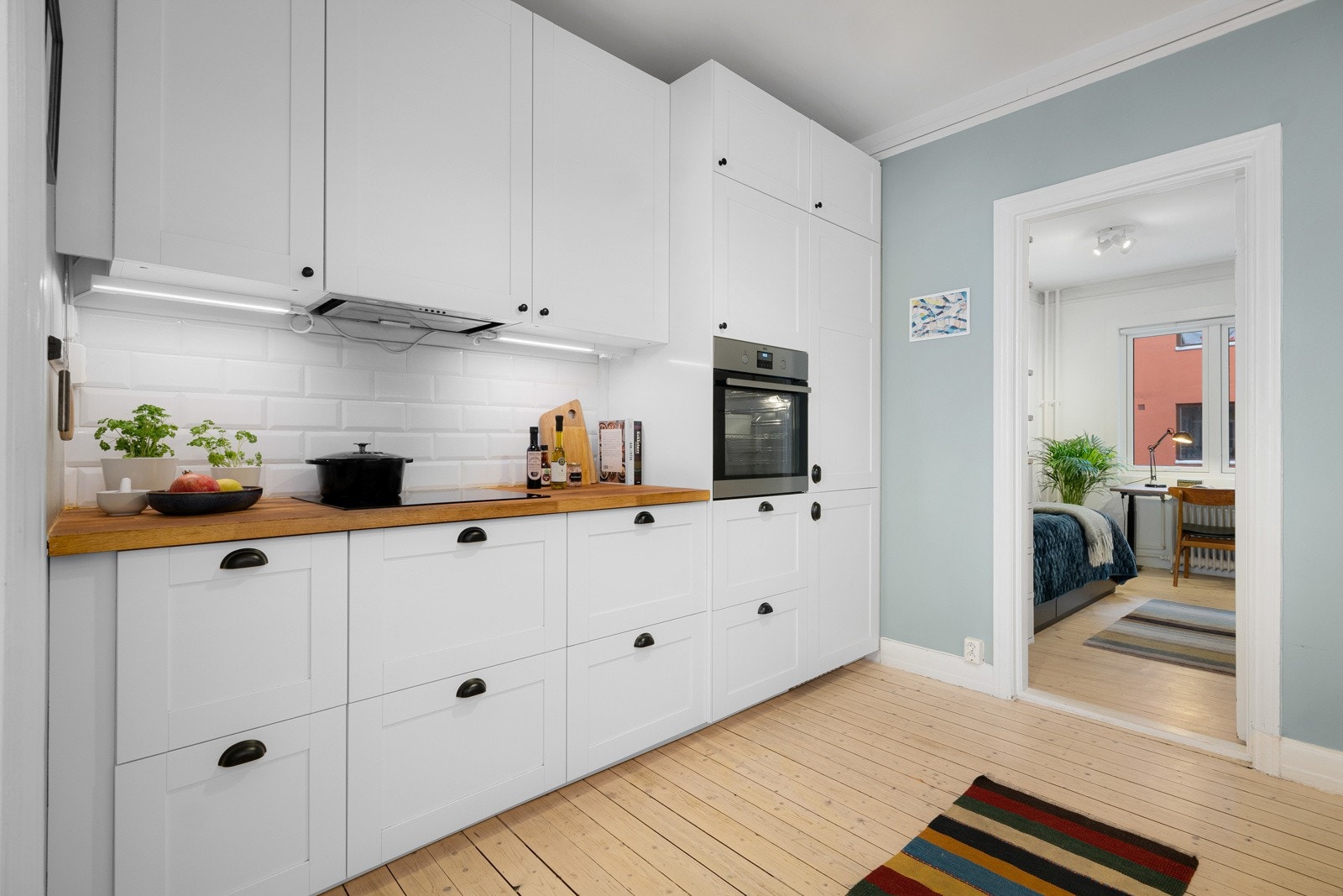 Kjøkkeninnredning fra 2016 med lyse profilerte fronter, benkeplate i heltre og nedfelt oppvaskkum. Galleribilde