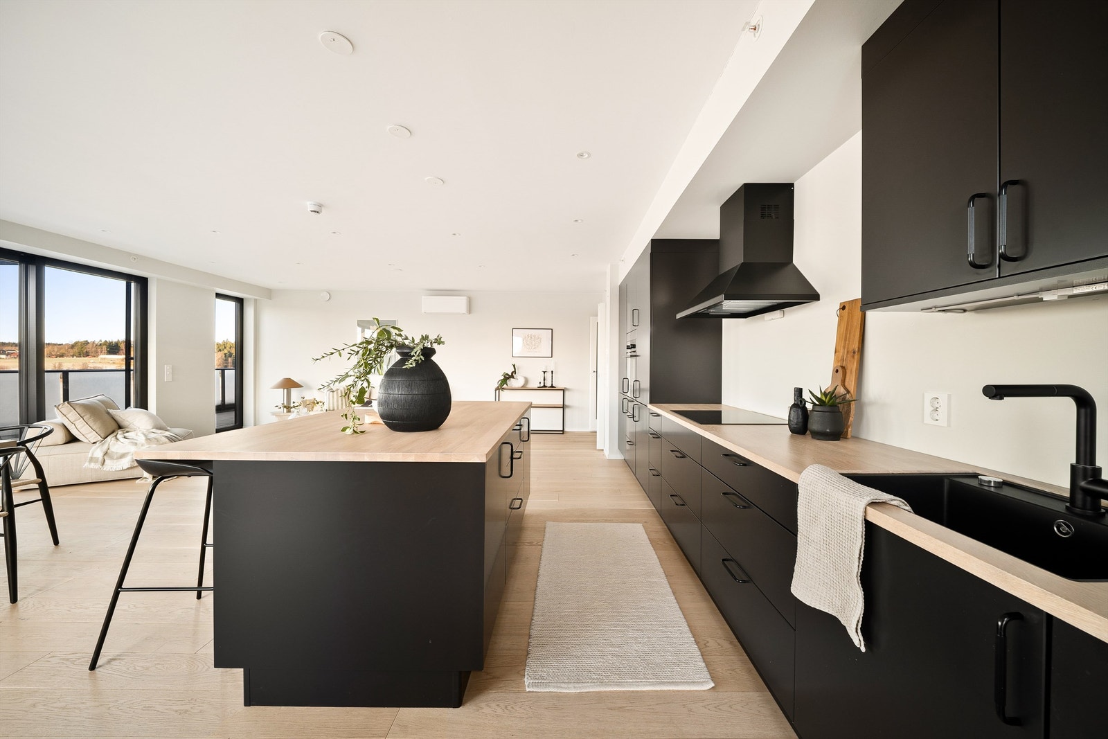 Mange oppbevaringsmuligheter og store arbeidsflater gjør kjøkkenet effektivt. Praktisk er det i tillegg med stor vask av underlimt modell. Benkeplatene er i heltre. Galleribilde