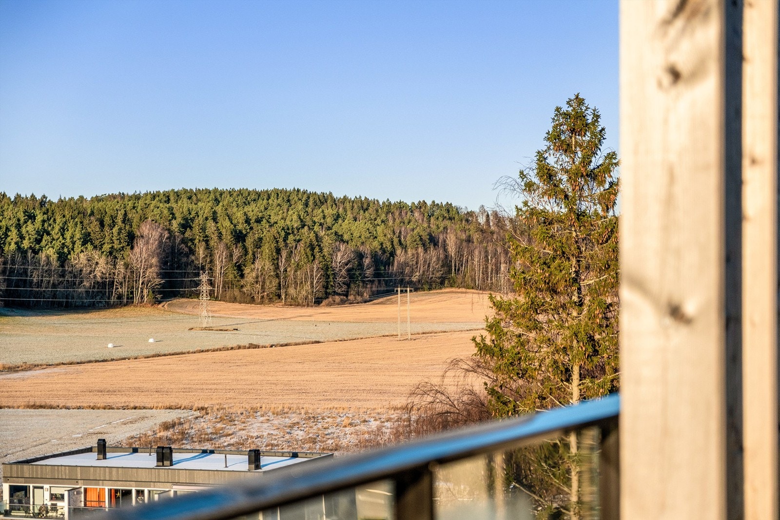 På altanen sees vid utsikt over dalen med åkerlandskap og skogholt - her mot nord-vest. Galleribilde