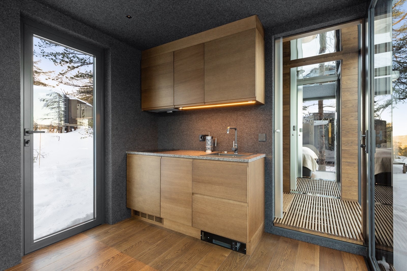 Frontene er produsert i finert eik og med grep og kantlister i massiv eik. Kjøleskap, oppvaskmaskin, koketopp, avtrekksvifte. Softclose på alle skuffer og dører. Og lekker benkeplate i stein - Anortositt. Galleribilde