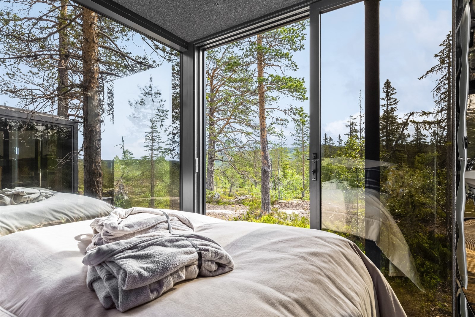 Skyv dørene til side i stuen og visk bort skillet mellom ute og inne - eller inviter den friske luften inn på
soverommet. Panoramadørene gjør overnattingen din til en helt unik og naturnær opplevelse - uansett
vær. Galleribilde