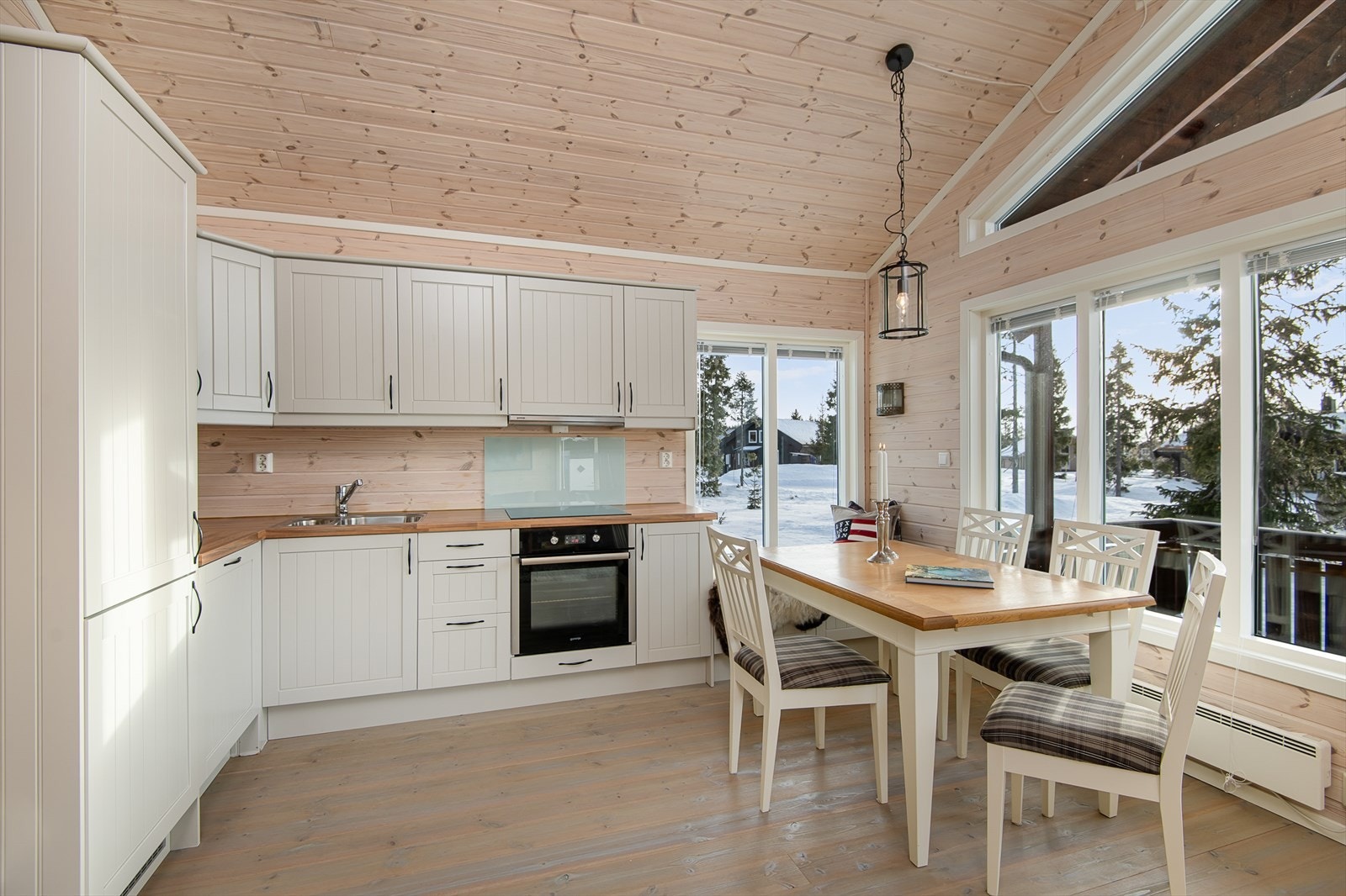 Kjøkken med spiseplass er fint plassert foran vinduene. God takhøyde og rikelig med naturlig lys inn gir en fin romfølelse. Galleribilde