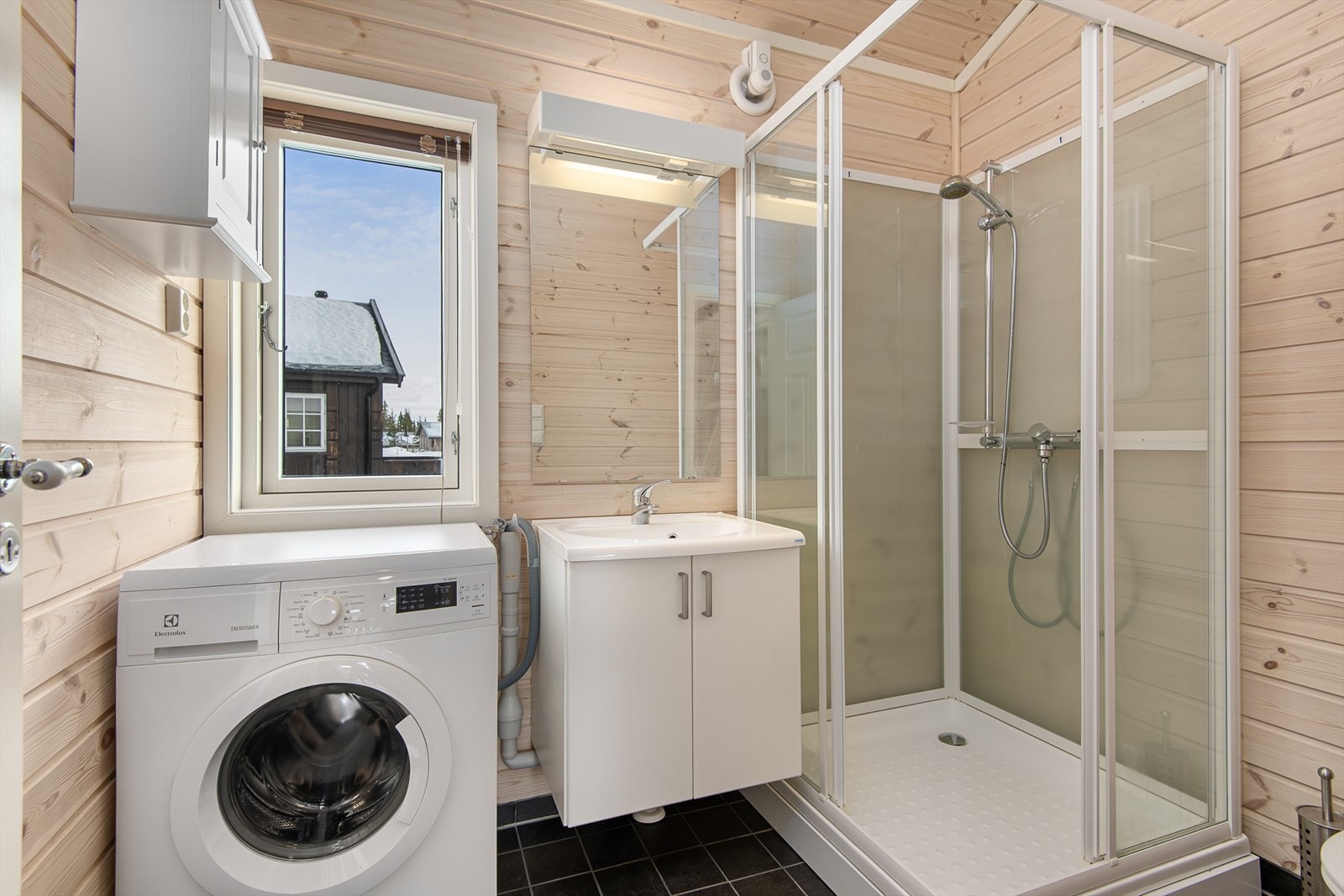 Funksjonelt bad med dusjkabinett, servantinnredning, wc og opplegg for vaskemaskin. Galleribilde