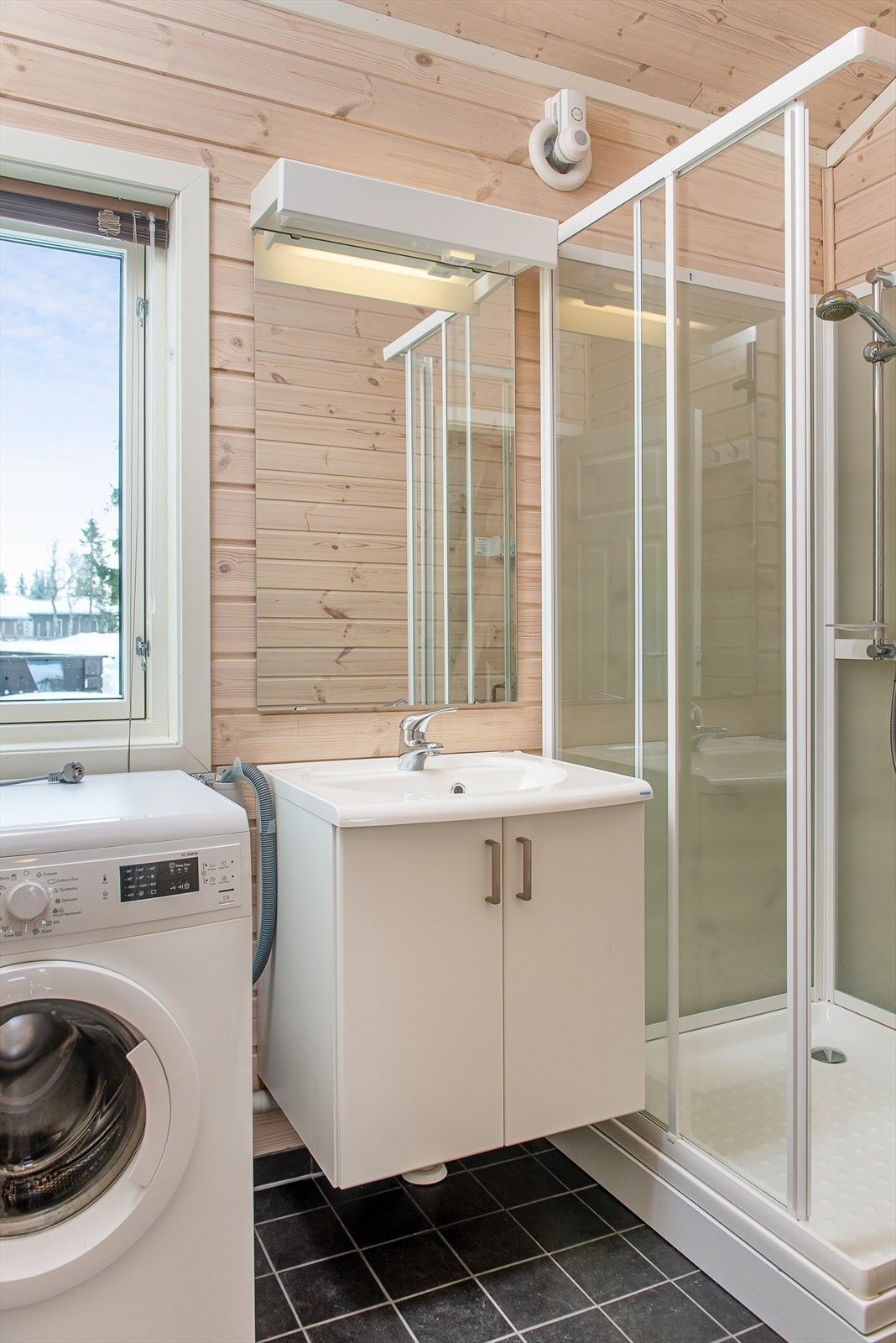 Servantinnredningen har skap for oppbevaring. Vegger og tak har behandlet panel. Flislagte gulv med varmekabler. Galleribilde