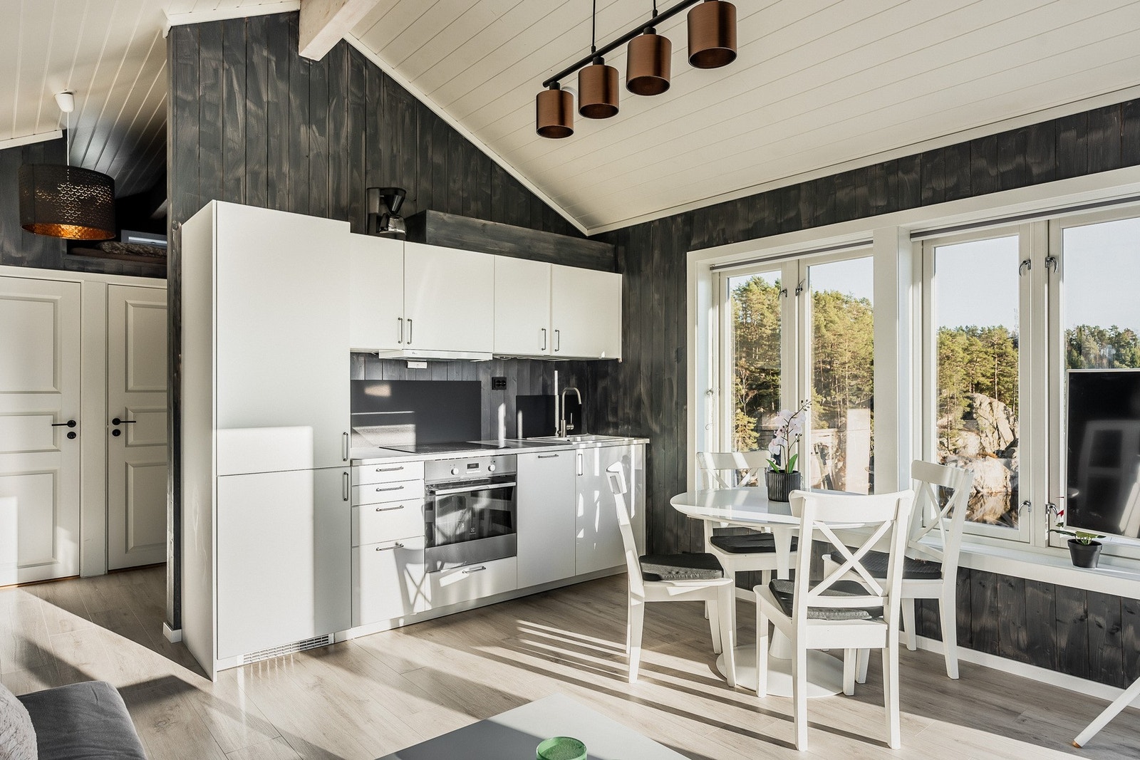 Pen innredning fra Ikea med integrerte hvitevarer som inkluderer induksjonstopp, stekeovn, oppvaskmaskin og kjøleskap med fryser. Galleribilde