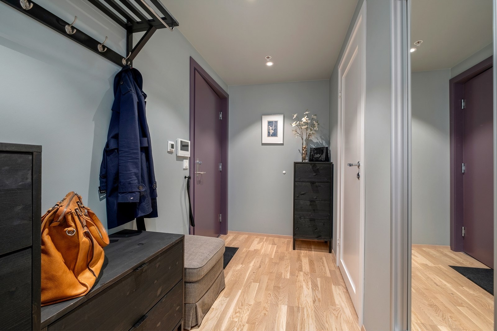 Leiligheten har en stor og godt utnyttet entré på 9,5 m² med gulvvarme og dobbelt garderobeskap fra Drømmekjøkkenet. Her kan man enkelt innrede med både kommoder og skohylle for oppbevaring av yttertøy og sko. Galleribilde