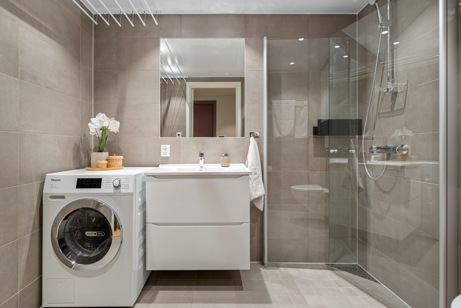 Baderommet fremstår som stilrent med varme i gulv og godt avtrekk. Galleribilde