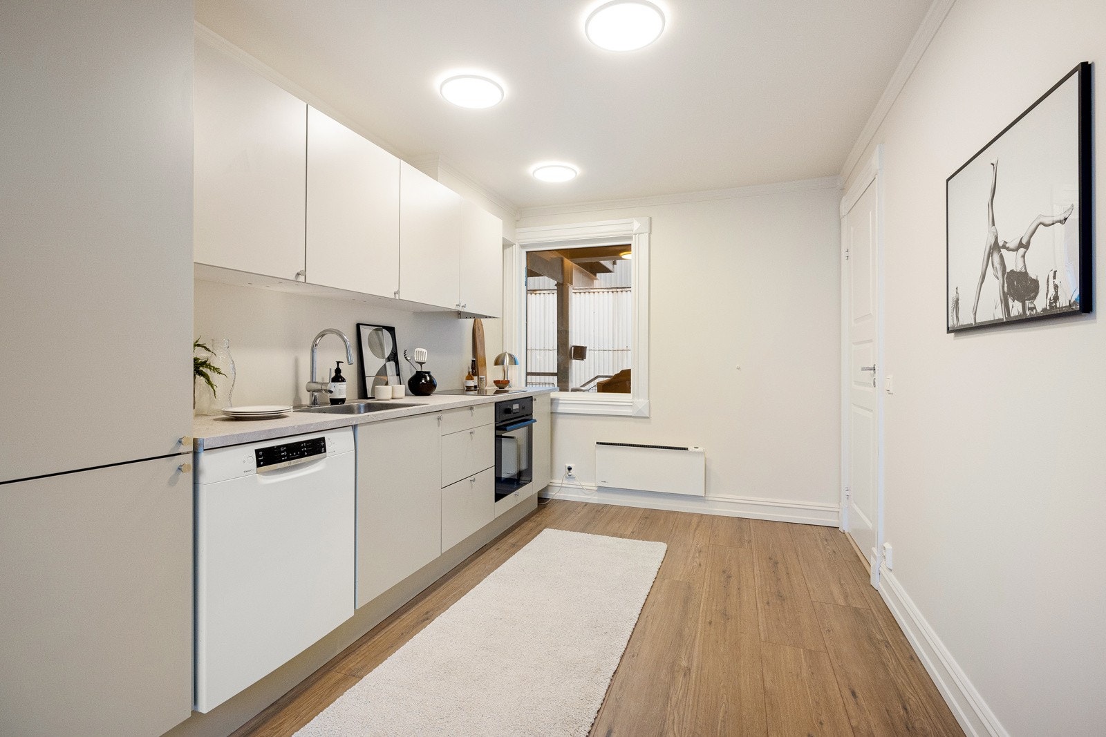 Lekker HTH-kjøkkeninnredning fra 2025, med glatte beige fronter og 28 mm tykk laminatbenkeplate. Galleribilde