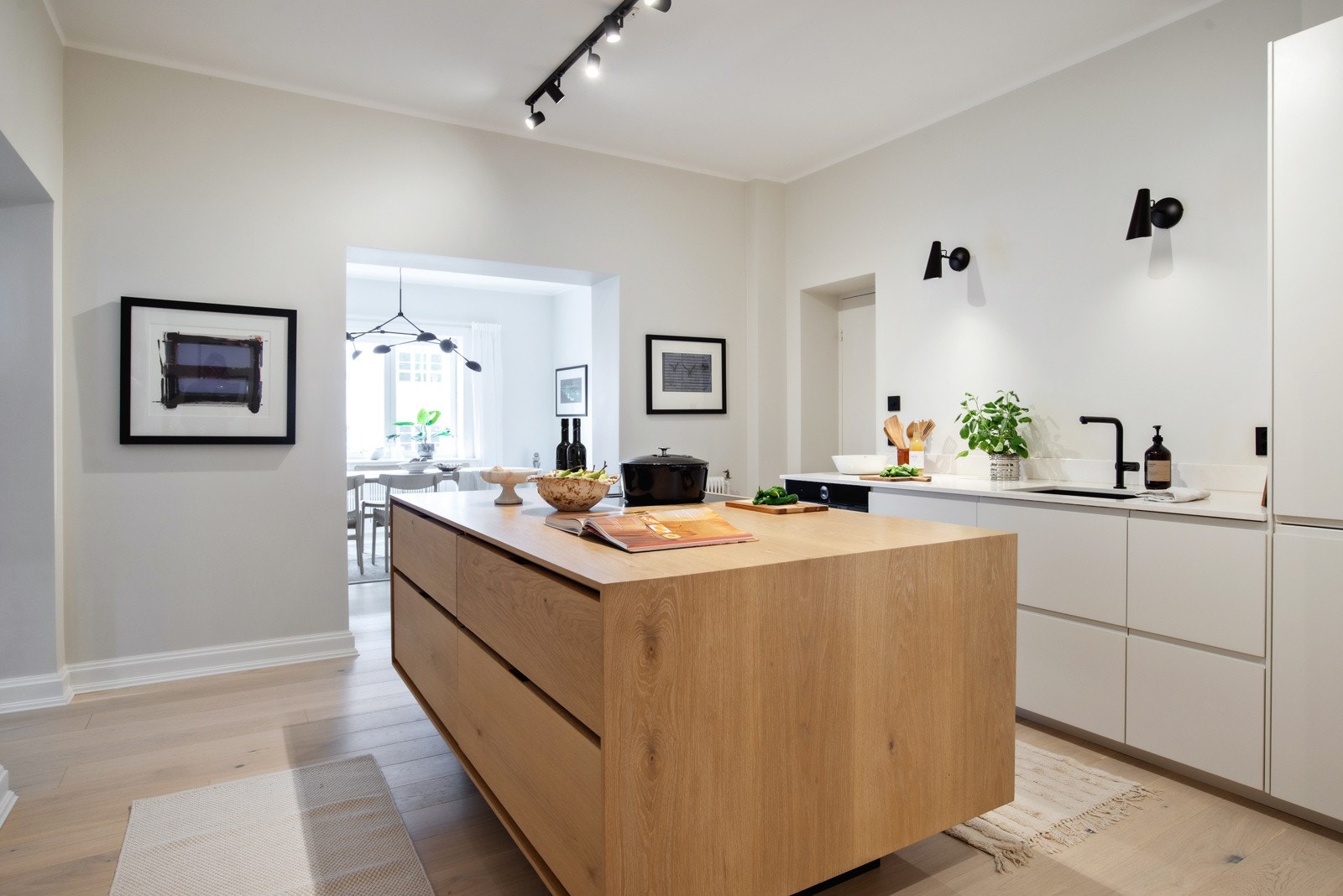 Stilrent og moderne kjøkken med glatte overflater i hvit og eikefiner utførelse. Galleribilde