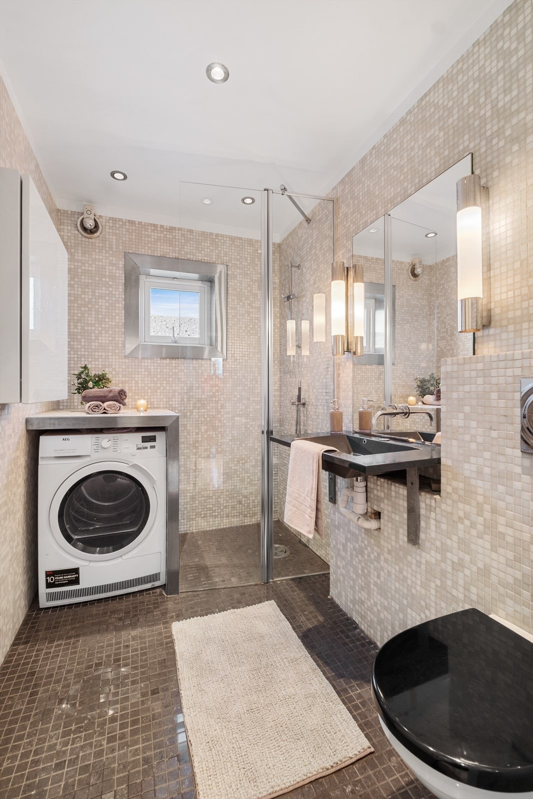 Badet er utført med flislagte overflater og har oppvarming med elektriske varmekabler Galleribilde