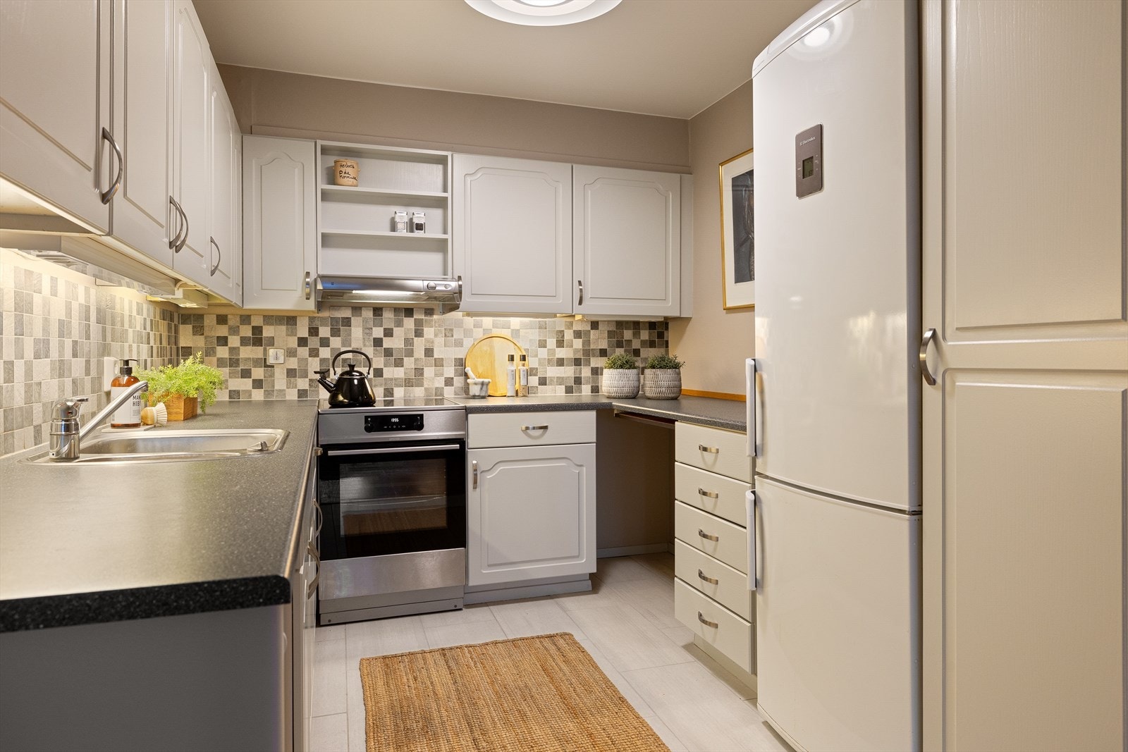 Kjøkkenet ligger i forlengelse av stuen og er praktisk utformet med store arbeidsflater og gode oppbevaringsmuligheter Galleribilde