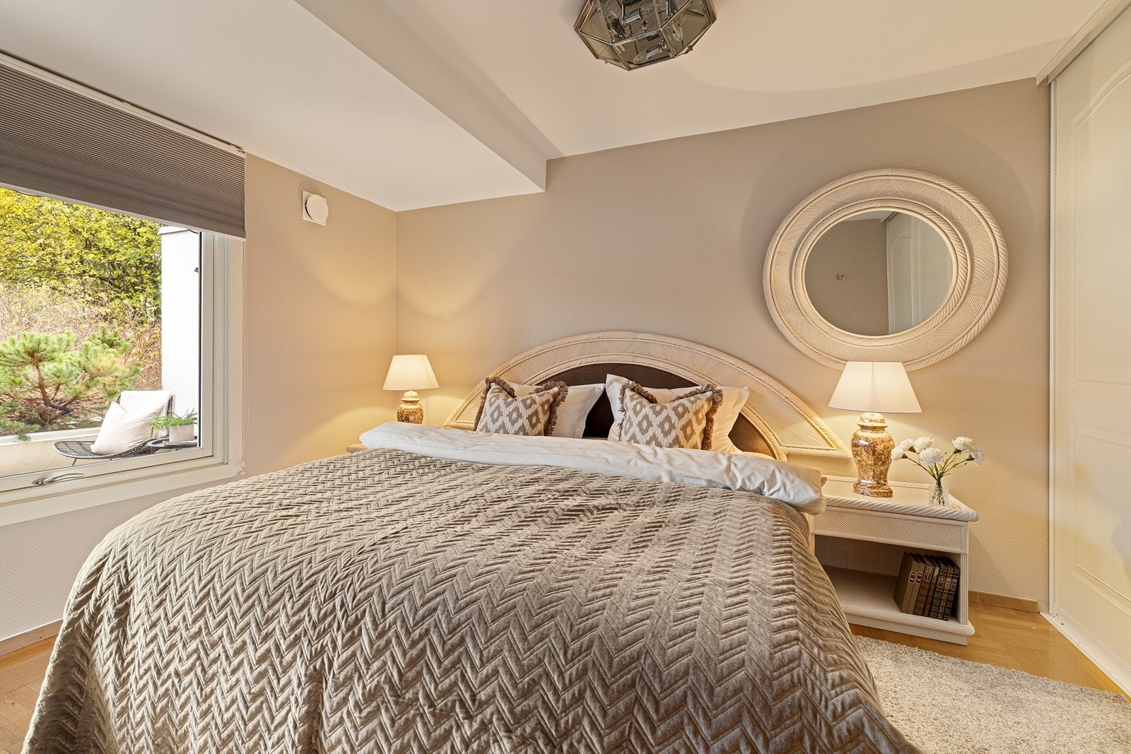 Romslig og lunt hovedsoverom med parkettgulv og lyse tapetserte veggflater, sist malt i 2019 Galleribilde