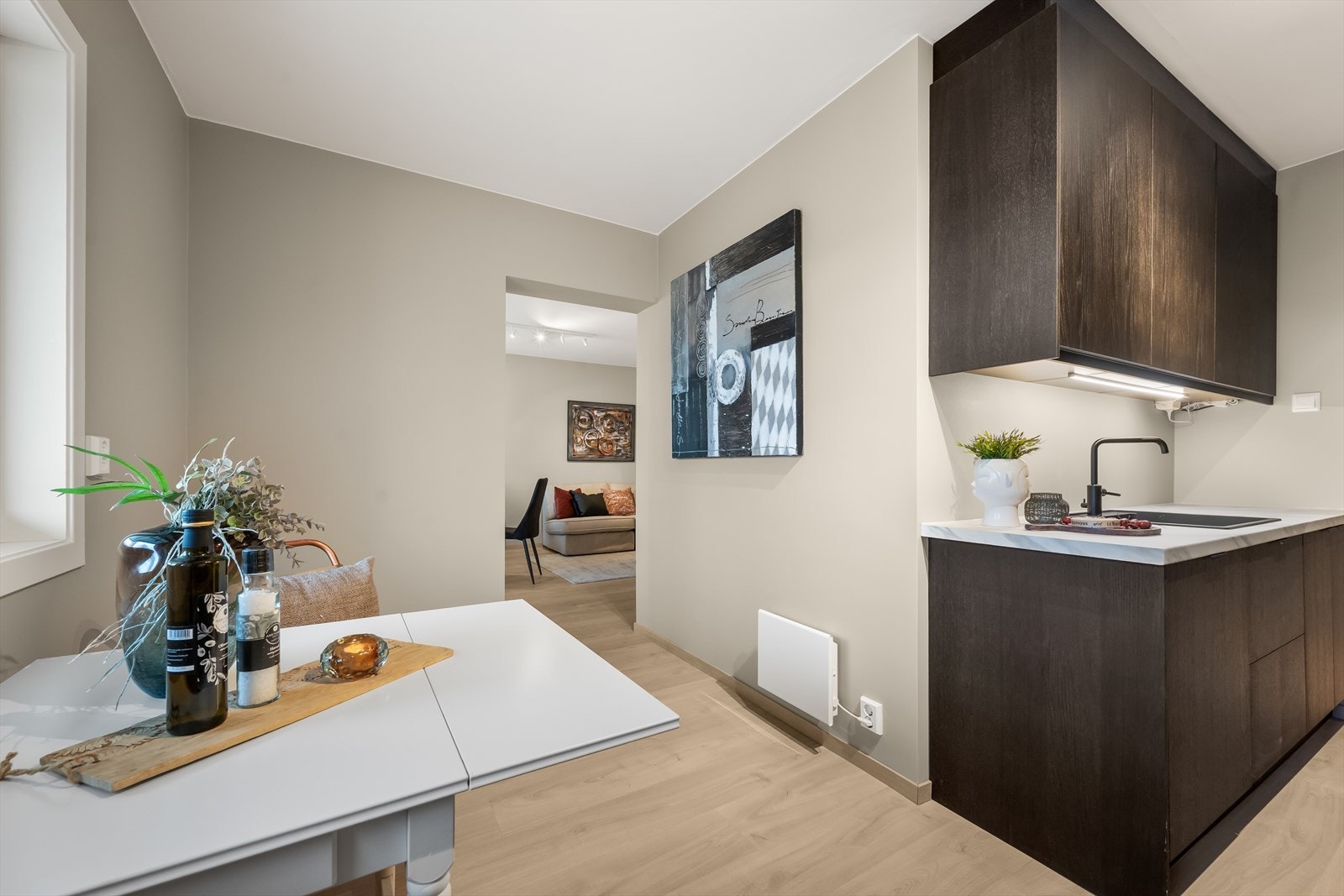 Det moderne kjøkkenet har rikelig med skapplass og benkeplass, noe som gir både praktisk oppbevaring og god arbeidsflate til matlaging. Galleribilde