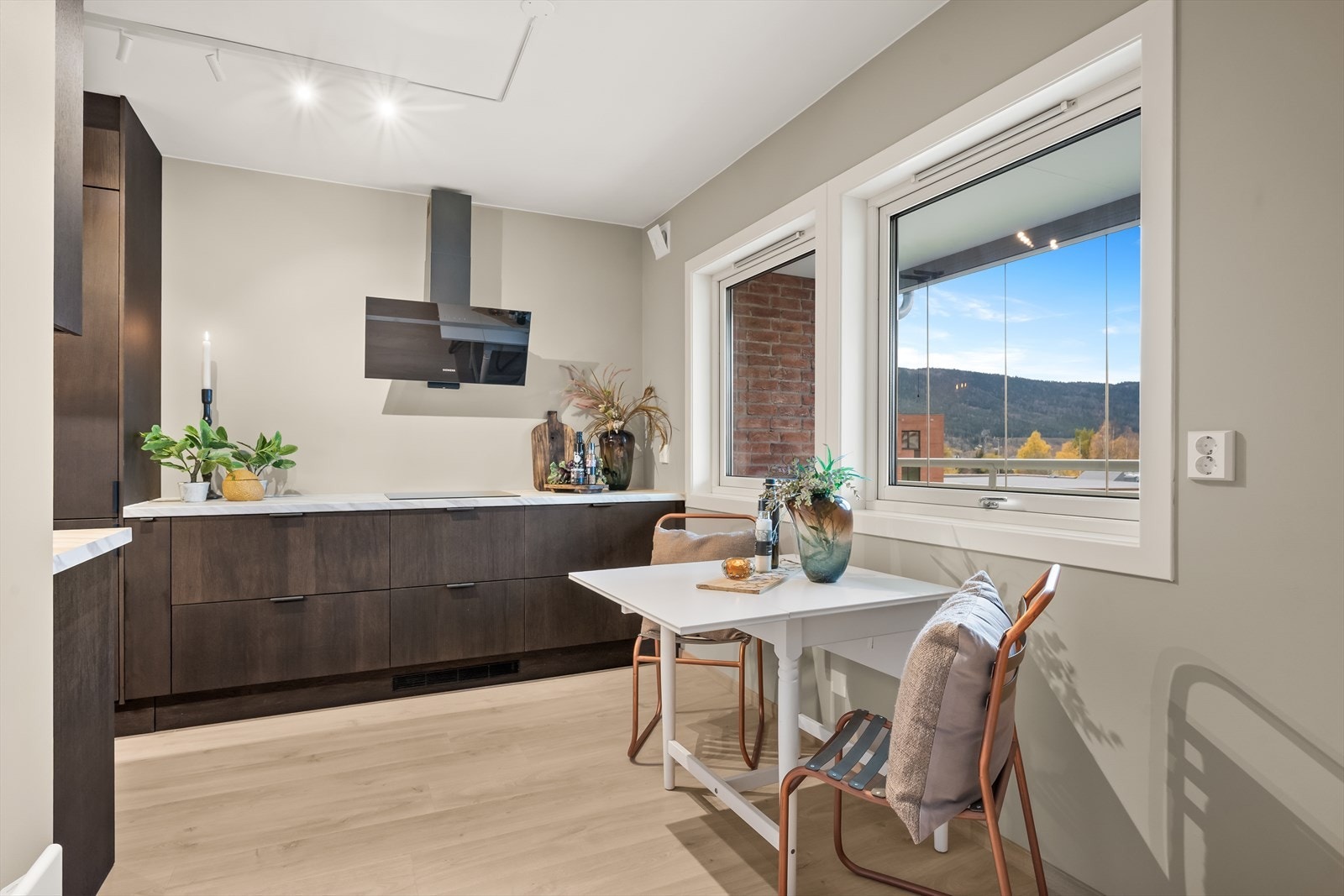 Moderne og tidløs kjøkkeninnredning med mørke slette fronter og benkeplate av laminat. Kjøkkenet er fra 2025. Galleribilde