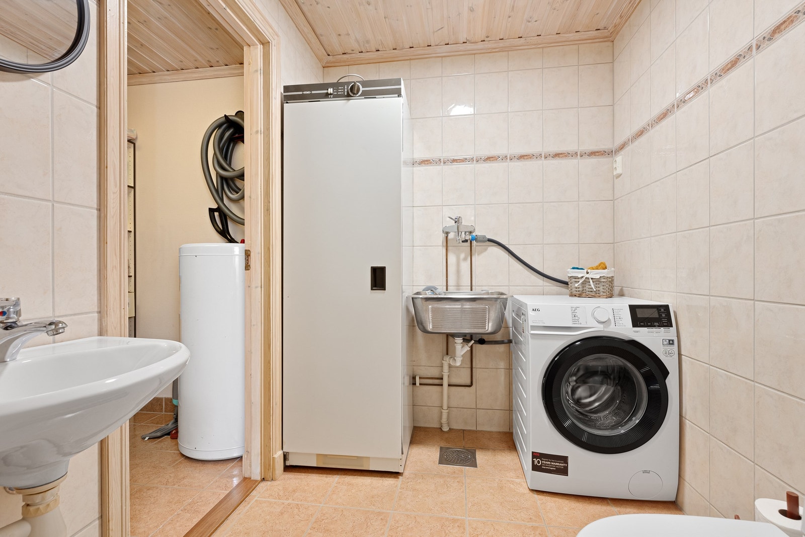 Rommet har opplegg for vaskemaskin, utslagsvask og tørkeskap. Galleribilde