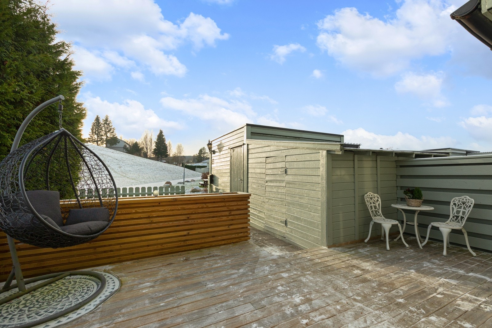 Romslig terrasse på ca. 21 kvm foran inngangspartiet, med god plass til stor sittegruppe og tilhørende møblement. I tillegg følger to boder som gir rikelig med lagringsplass. Galleribilde