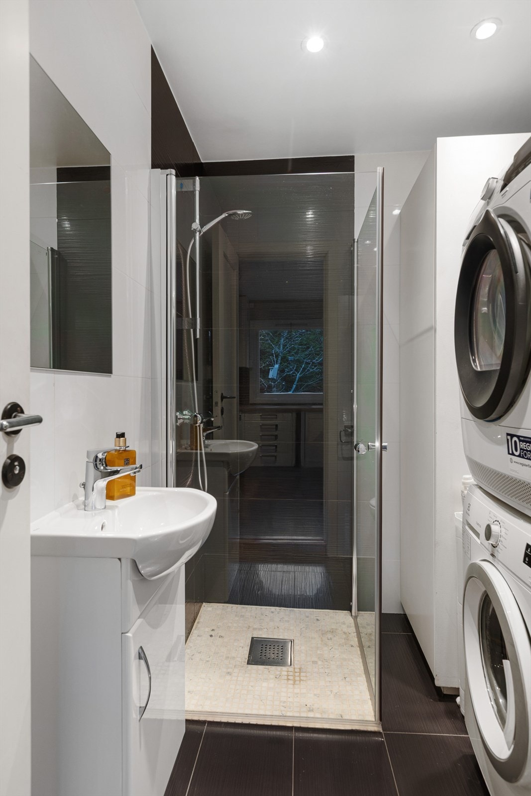 Boligen har to flislagte og stilrene baderom, oppgradert i 2018. Hvert baderom er elegant innredet med servant med slette fronter, veggmontert toalett og dusjhjørne med to svingbare glassdører. Galleribilde