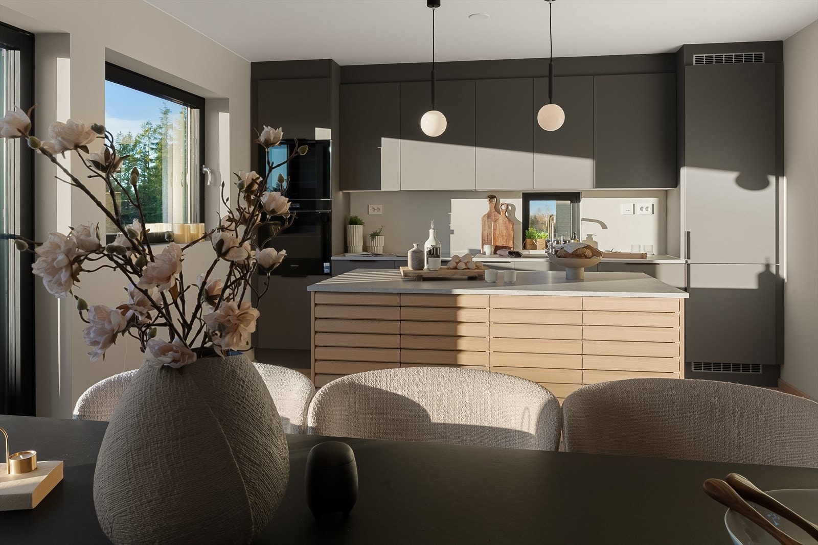 Kjøkkenøya har lyse, trehvite rillefronter som matcher parkettgulvet. Benkeplate er i 20 mm laminat i fargen sandsten . Galleribilde