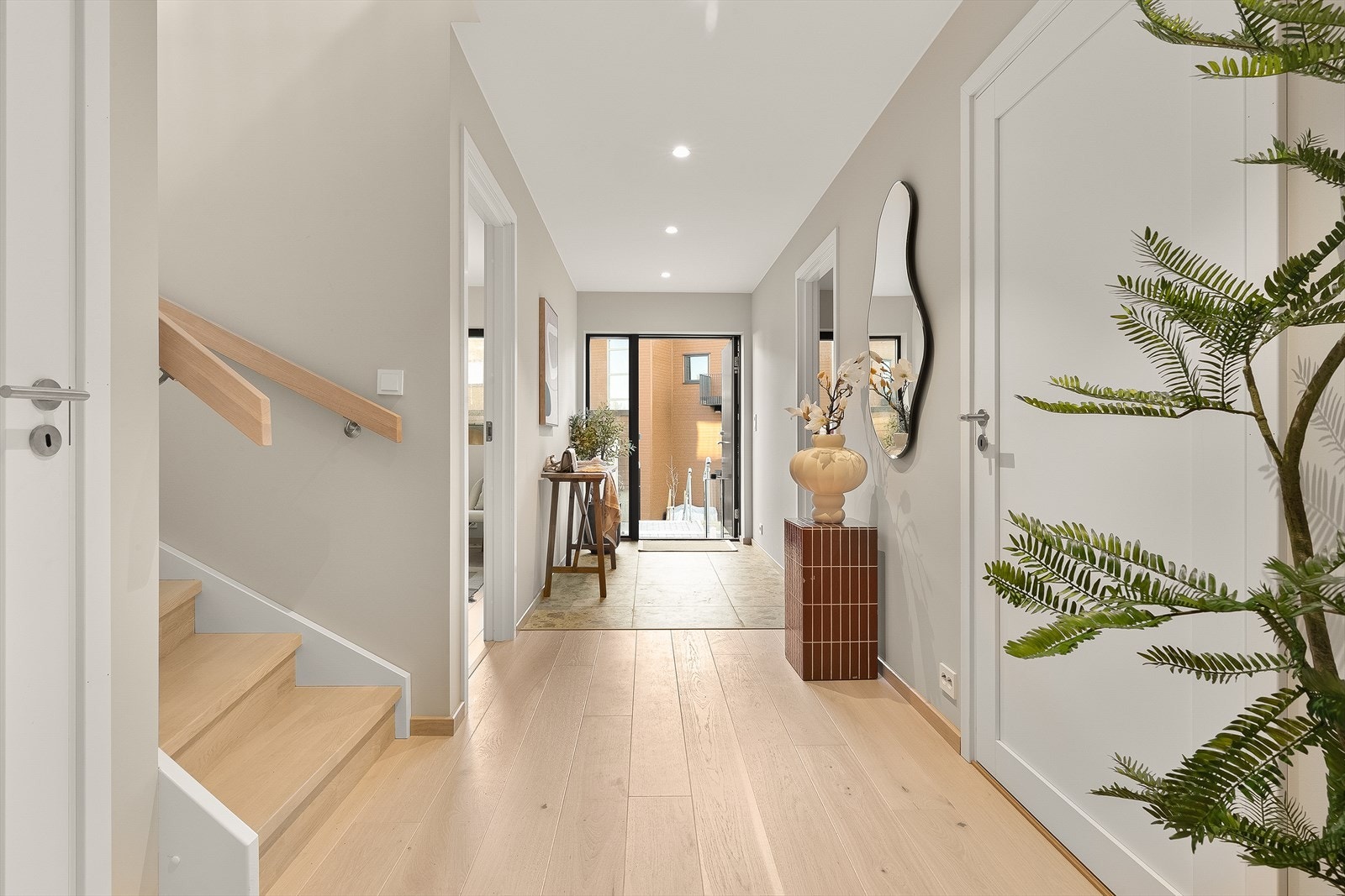 Trappen fra 1. etasje til 2. etasje har tette trinn og håndløper som matcher parketten. Det er bod under trappen. Galleribilde