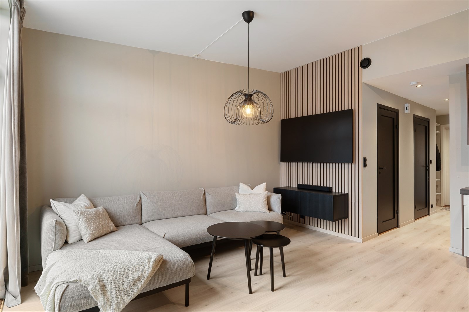 En flott stue med god takhøyde. Malt i en lun fargetone med spilevegg som en kontrastvegg. Galleribilde