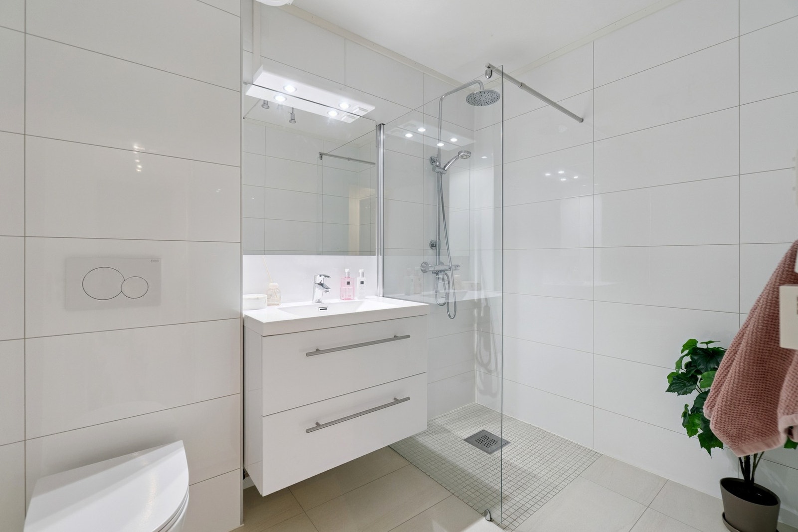 Badet ble også oppgradert i 2019, og har en tidløs hvit og lys utførelse. Her finner du blant annet vegghengt toalett, servantskap, gulvvarme, dusjsone med veggarnityr og glassvegg. Galleribilde