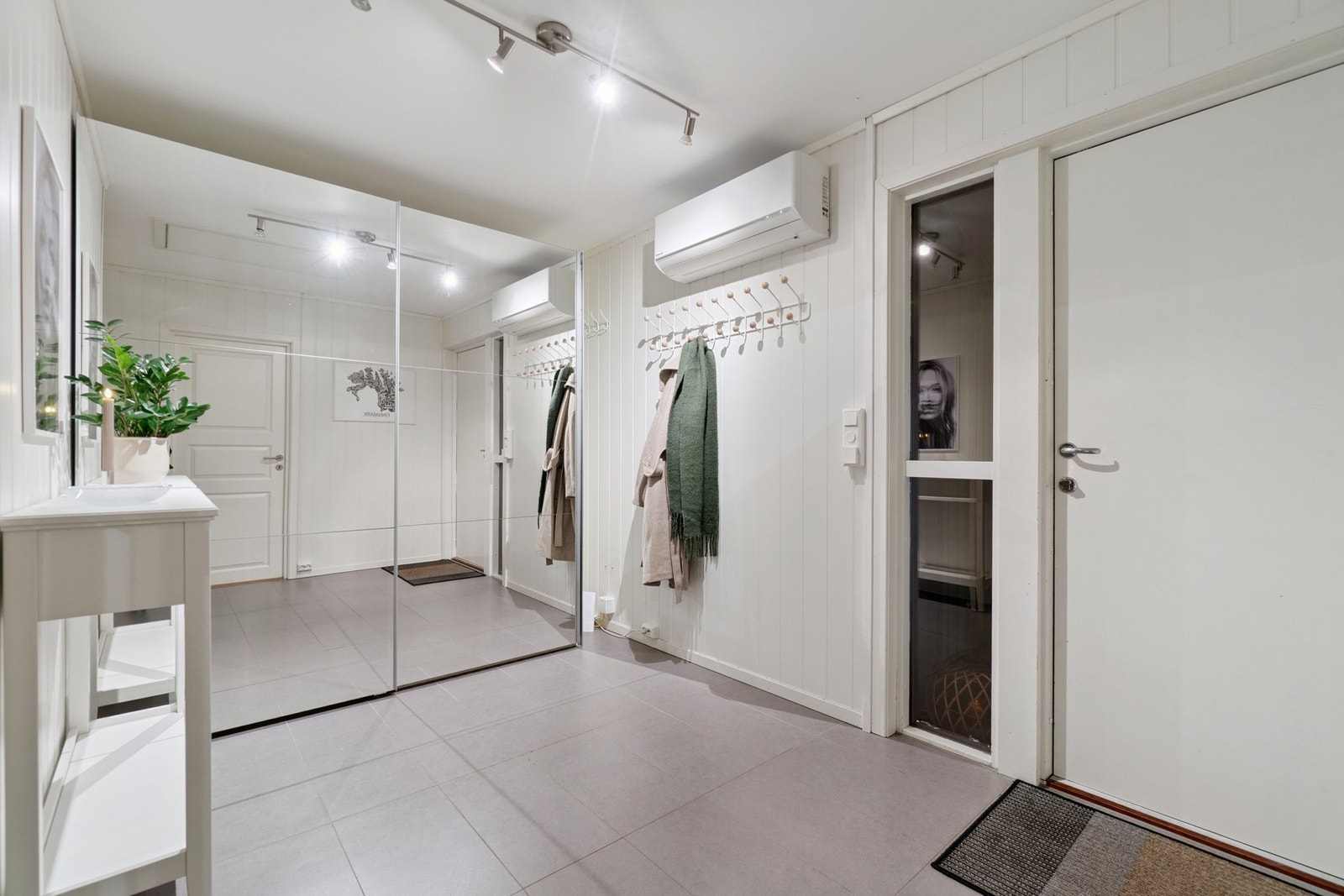 I entréen/gangen er det fliser på gulv med gulvvarme, skyvedørsgardeobe med speildører, og en ellers tidløs og innbydende utførelse på vegger og himling. Galleribilde