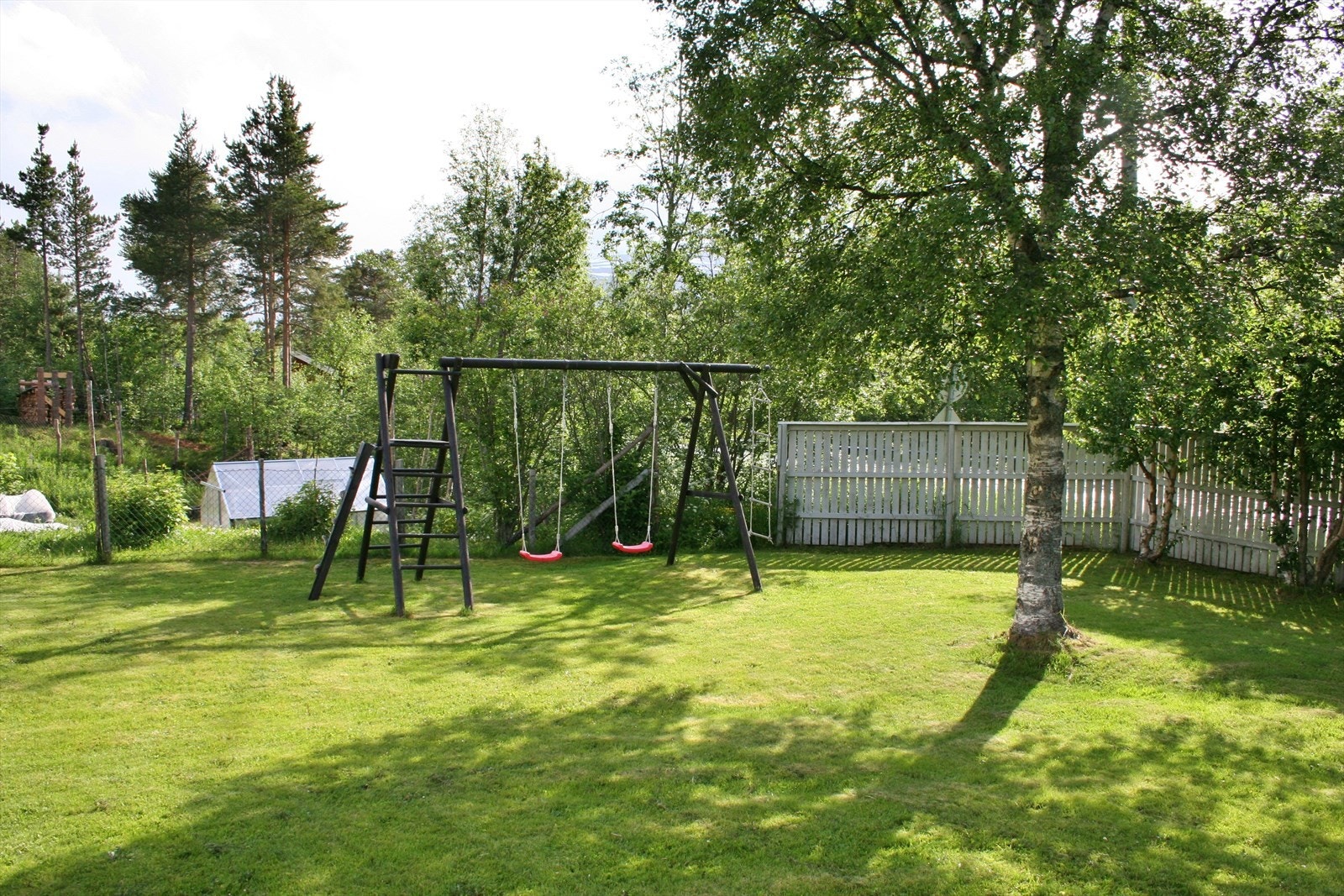 Huske-/klatrestativ i hjørnet av hagen Galleribilde