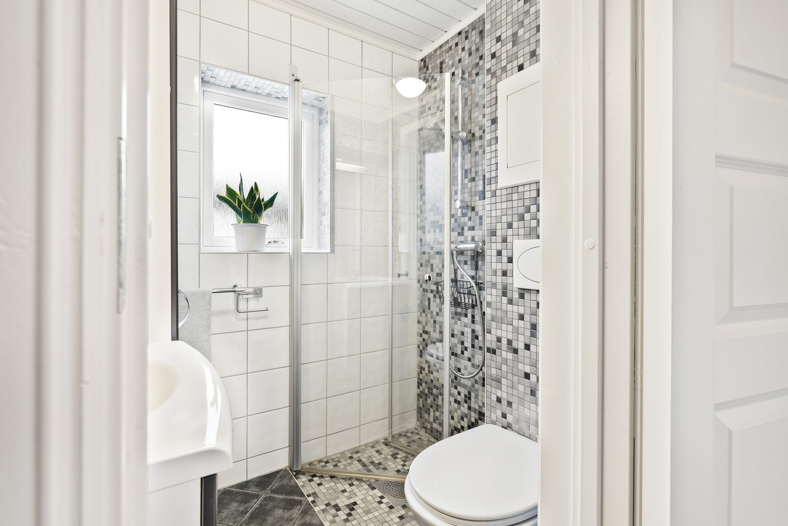 Det er fliser på vegger og gulv, og varmekabler i gulvet. Galleribilde